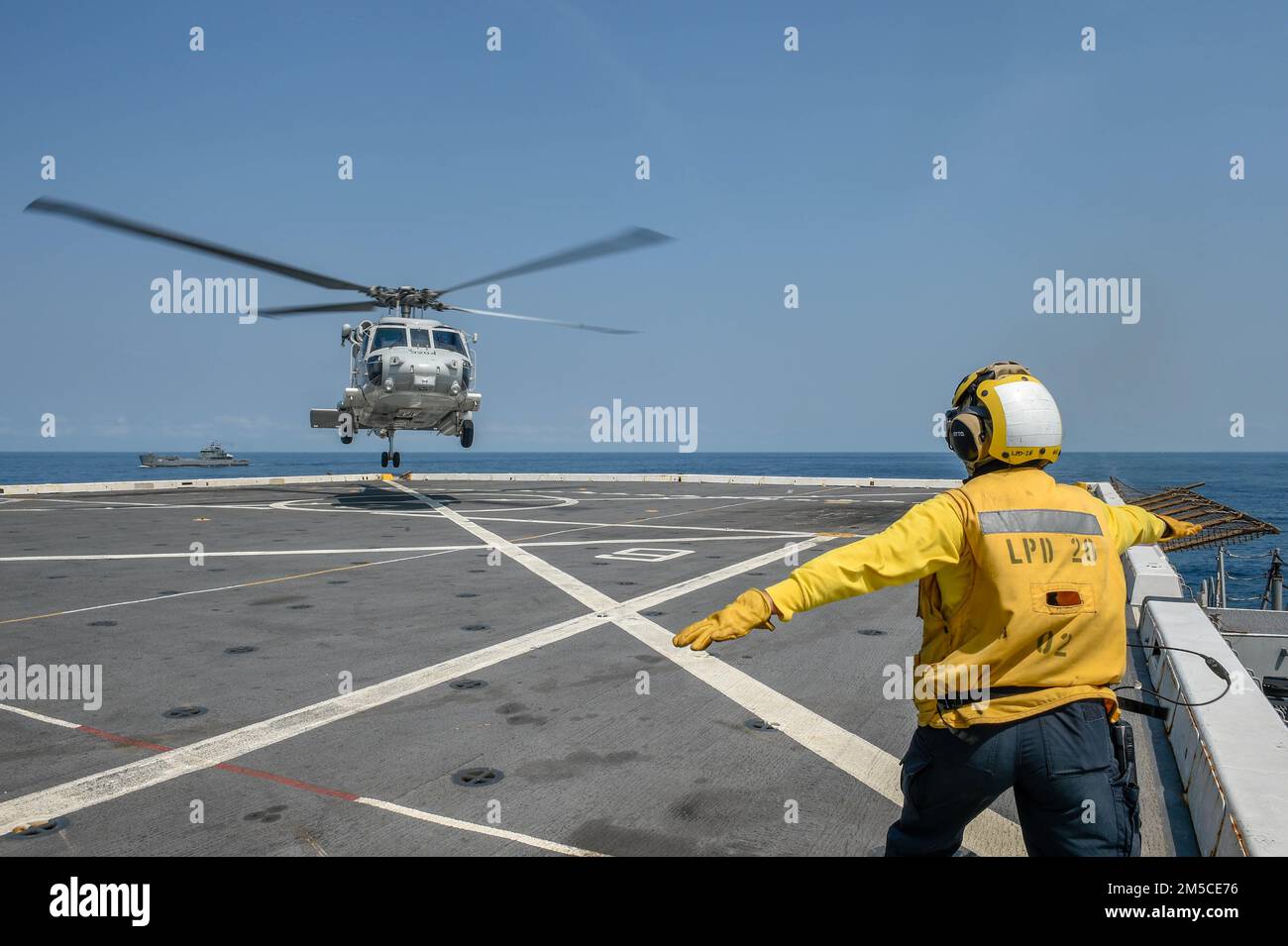 GULF OF THAILAND (March 1, 2022) Aviation Boatswain’s Mate (Handling) 2nd Class Sheinina Ulama, from Farmington, Minn., assigned to the amphibious transport dock ship USS Green Bay (LPD 20), signals an SH-70B Sea Hawk helicopter from the Royal Thai Navy to land on the flight deck during exercise Cobra Gold 22. Cobra Gold 2022 is the 14st iteration of the international training exercise that supports readiness and emphasizes coordination on civic action, humanitarian assistance, and disaster relief. From Feb. 22 through March 4, 2022, this annual event taking place at various locations througho Stock Photo