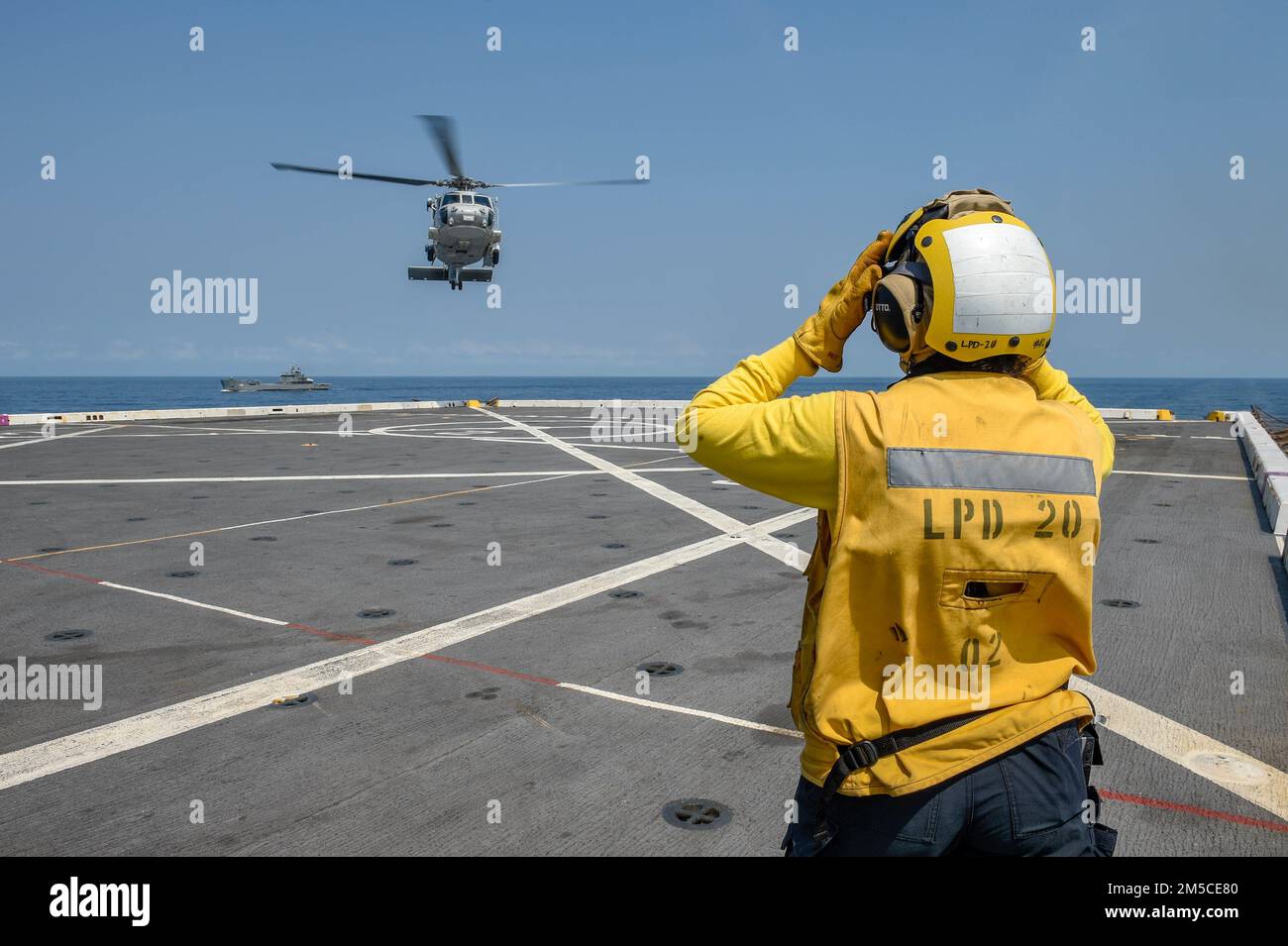 GULF OF THAILAND (March 1, 2022) Aviation Boatswain’s Mate (Handling) 2nd Class Sheinina Ulama, from Farmington, Minn., assigned to the amphibious transport dock ship USS Green Bay (LPD 20), signals an SH-70B Sea Hawk helicopter from the Royal Thai Navy to land on the flight deck during exercise Cobra Gold 22. Cobra Gold 2022 is the 14st iteration of the international training exercise that supports readiness and emphasizes coordination on civic action, humanitarian assistance, and disaster relief. From Feb. 22 through March 4, 2022, this annual event taking place at various locations througho Stock Photo