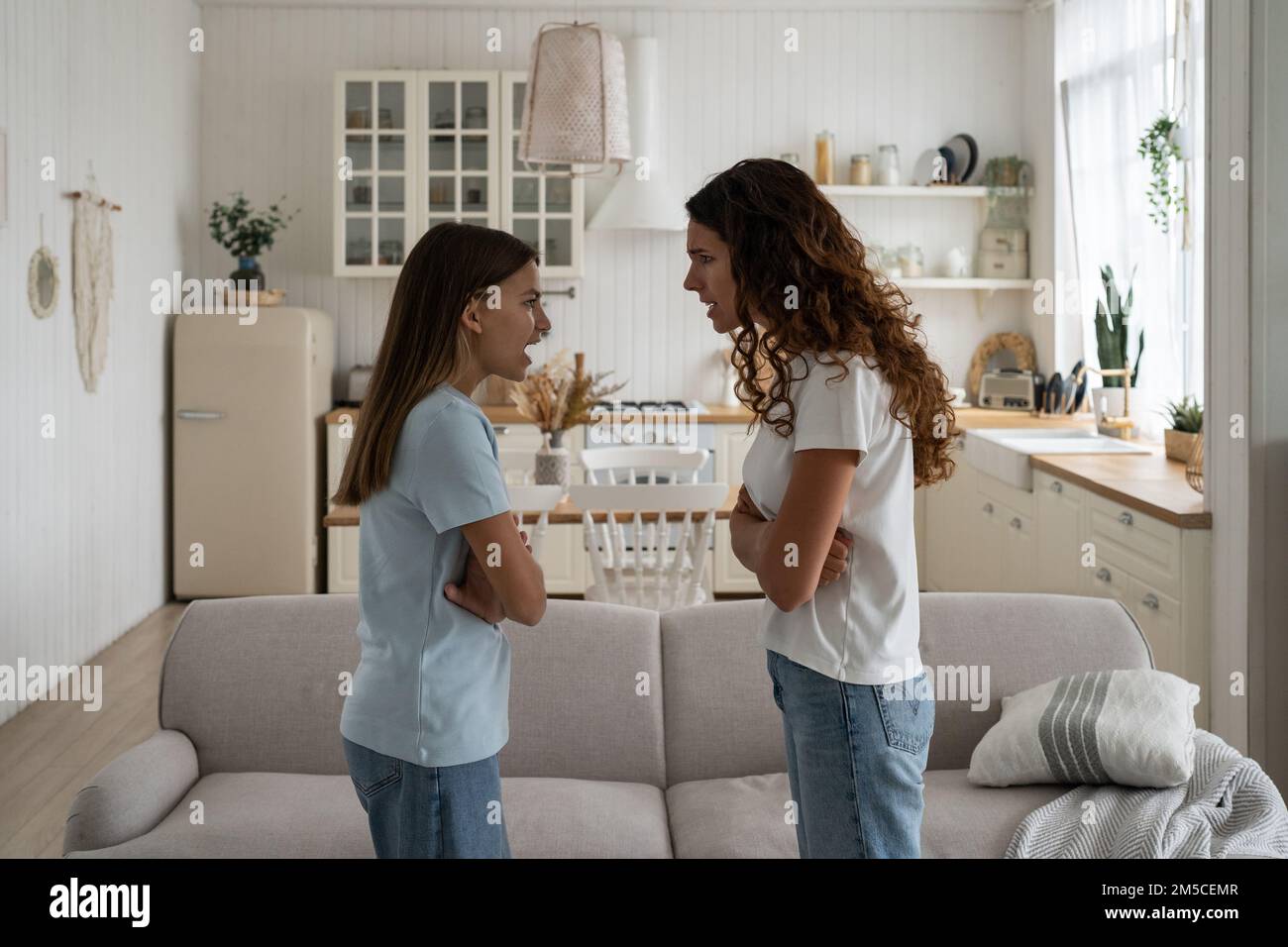 Mother parent having arguments with angry disrespectful teenage daughter at home Stock Photo