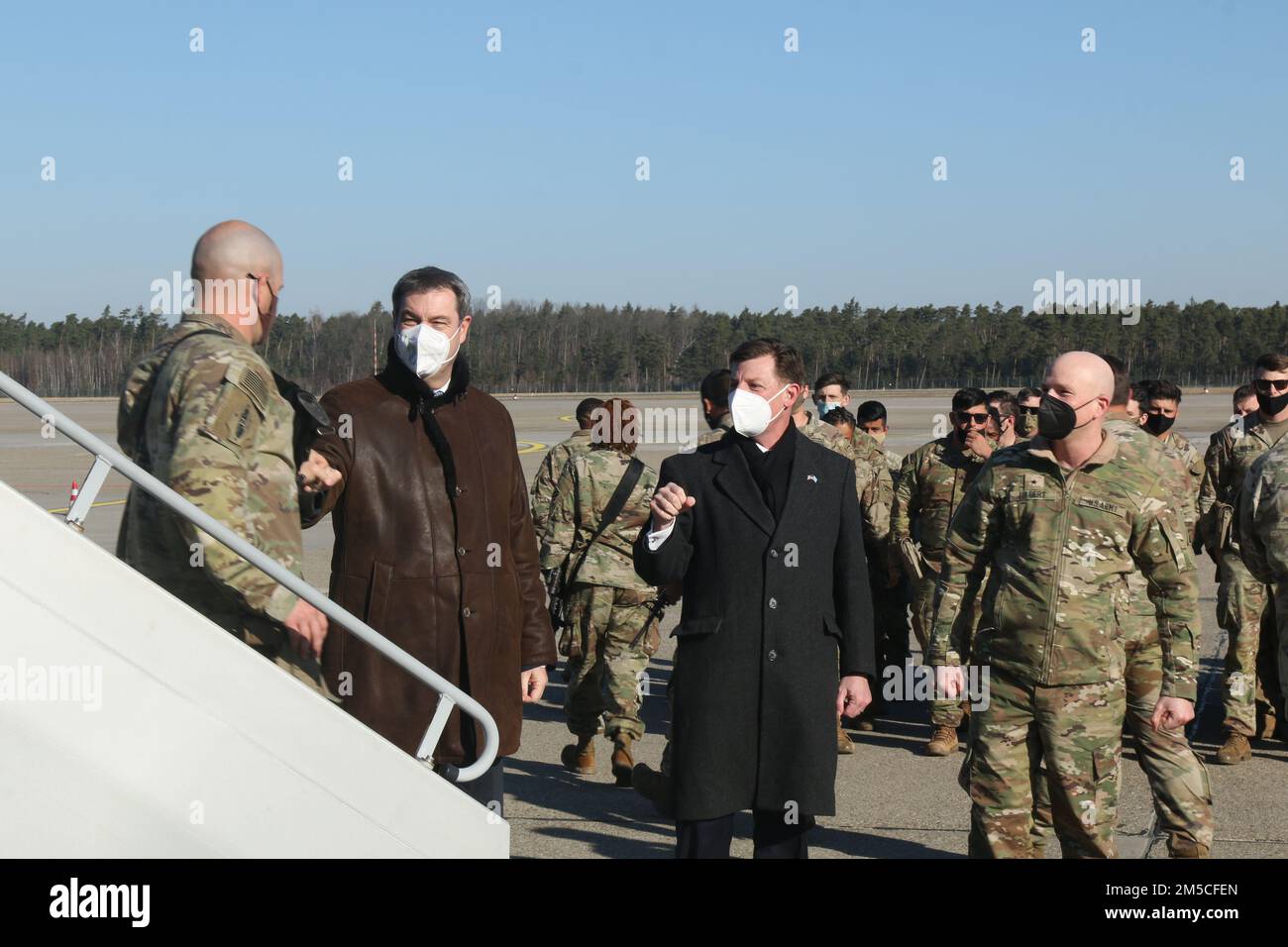 Markus Söder, Minister-President of Bavaria, Timothy Liston, United States Consul General in Munich, and Brig. Gen. Joseph E. Hilbert, commander, 7th Army Training Command, bumped fists with arriving Soldiers from 1st Armored Brigade Combat Team, 3rd Infantry Division as they touched down in Nuremberg, Germany, Mar. 1, 2022. As announced by the Department of Defense, the unit is deploying to Europe and will be based out of Grafenwoehr Training Area, where they will be issued equipment from Army Prepositioned Stocks-2, and conduct training. Stock Photo