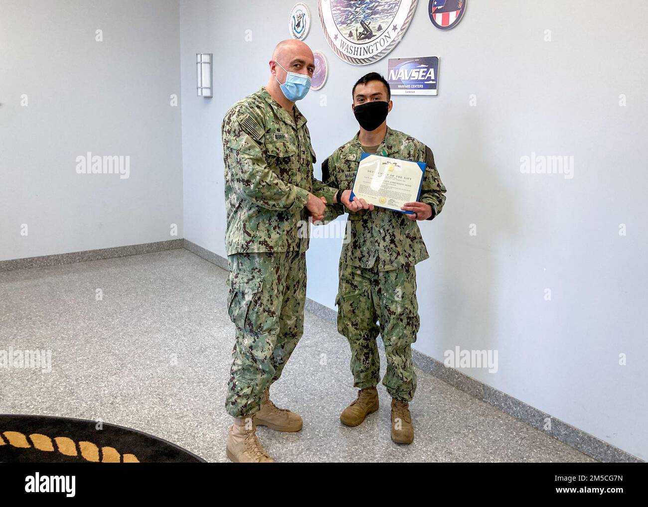 WASHINGTON, DC (March 1, 2022) – Capt. Mark Burns (left), Naval Support Activity Washington commanding officer, presents Religious Program Specialist 2nd Class Arvin Malin (right) with the Navy and Marine Corps achievement medal during an end-of-tour award ceremony held in Malin’s honor. Stock Photo