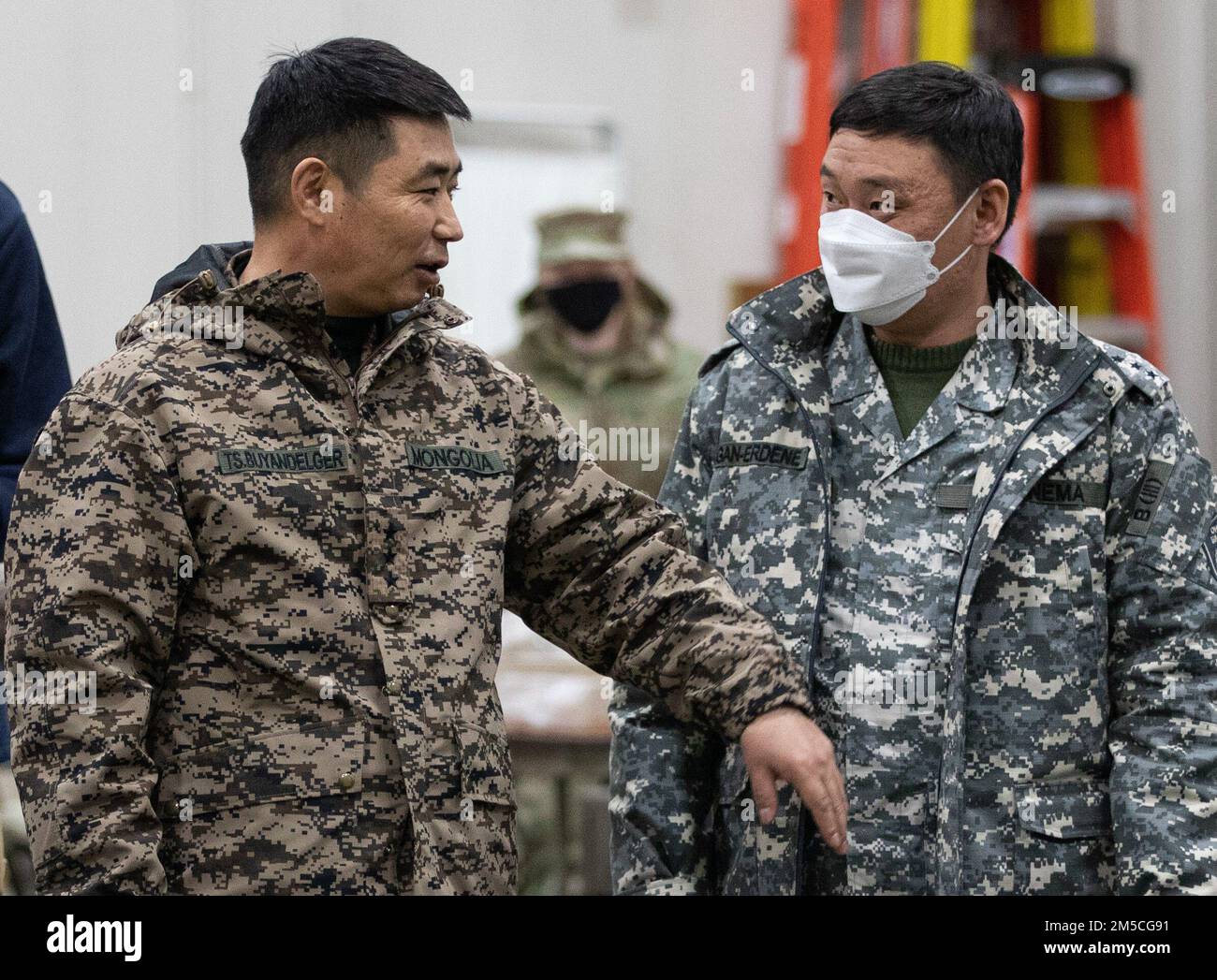 Mongolian Armed Forces Col. Buyandelger, a general staff member, and Cpt. Gan-Erdene of the Mongolian National Emergency Management Agency, observe training during Exercise Arctic Eagle-Patriot 22 at the Anchorage Fire Training Center in Anchorage, Alaska, March 1, 2022. Joint Exercise Arctic Eagle-Patriot 22 increases the National Guard’s capacity to operate in austere, extreme cold-weather environments across Alaska and the Arctic region. AEP22 enhances the ability of military and civilian inter-agency partners to respond to a variety of emergency and homeland security missions across Alaska Stock Photo