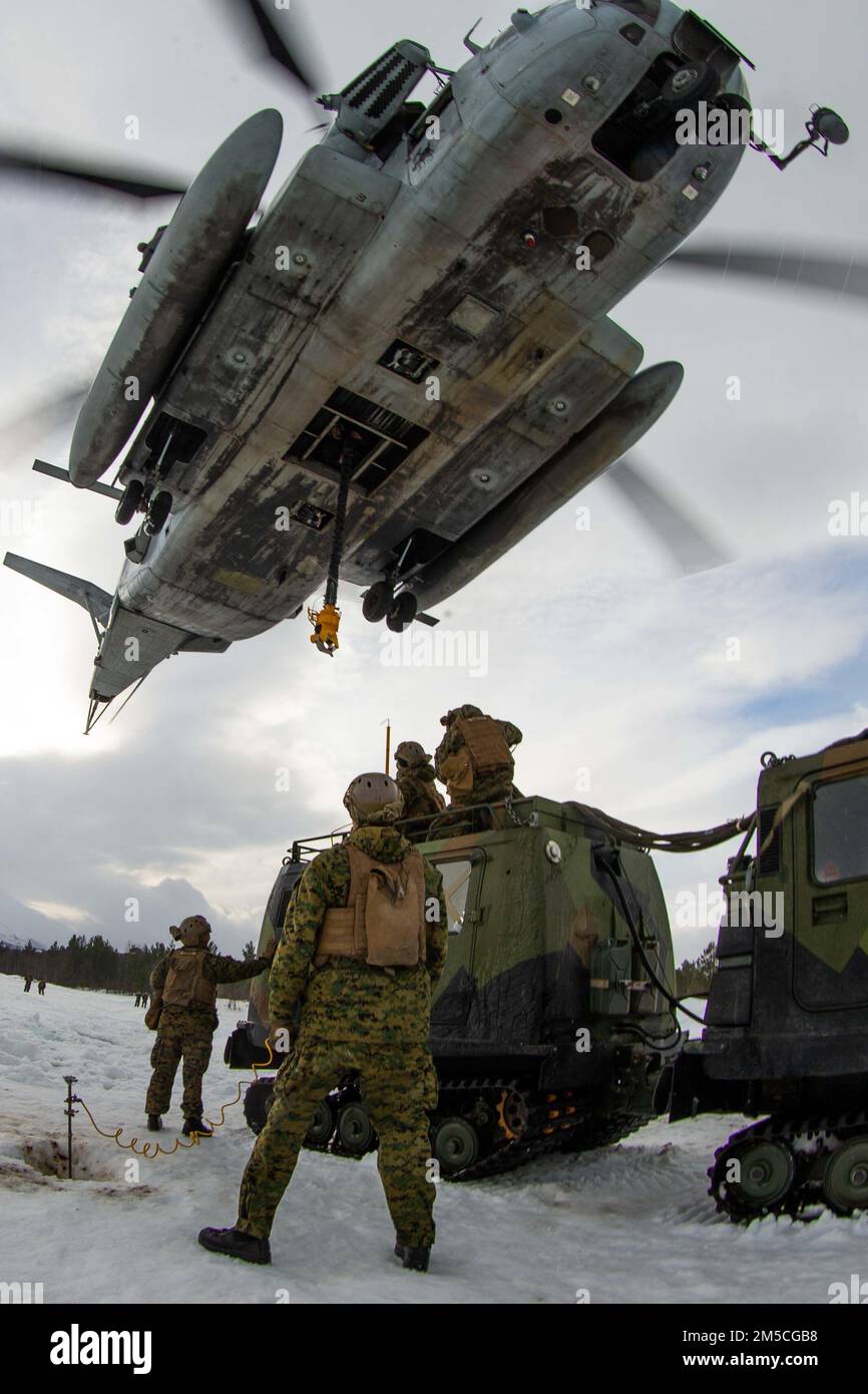 U.S. Marines with 2nd Landing Support Battalion, assigned to 3rd Battalion, 6th Marine Regiment, II Marine Expeditionary Force, prepare a Norwegian Bandvagn 206 to be lifted by a CH-53E Super Stallion with Marine Heavy Helicopter Squadron 366 (HMH-366), 2nd Marine Aircraft Wing, in preparation for Exercise Cold Response 2022, Bardufoss, Norway, Feb. 28, 2022. Exercise Cold Response '22 is a biennial Norwegian national readiness and defense exercise that takes place across Norway, with participation from each of its military services, as well as from 26 additional North Atlantic Treaty Organiza Stock Photo