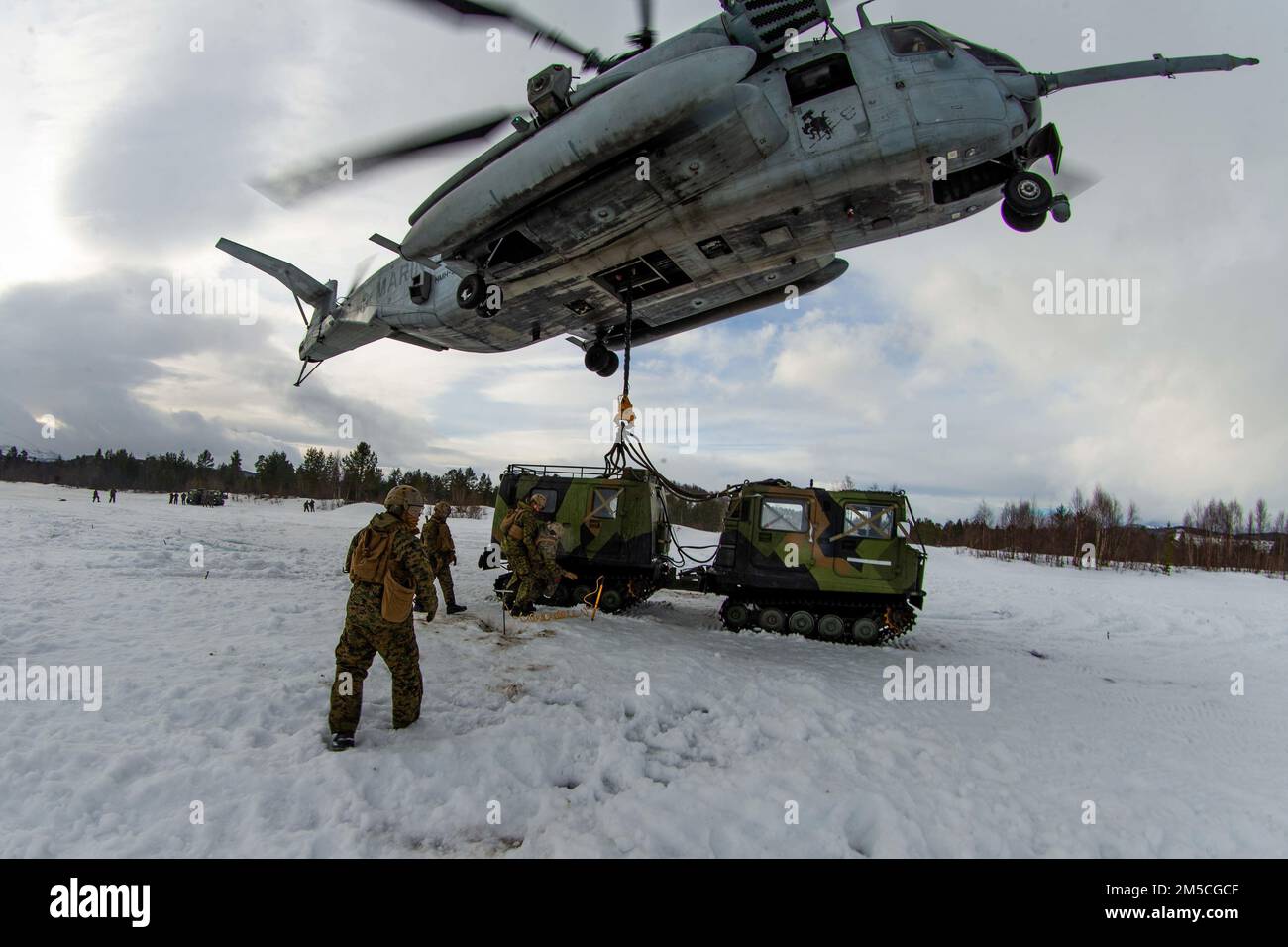 U.S. Marines with 2nd Landing Support Battalion, assigned to 3rd Battalion, 6th Marine Regiment, II Marine Expeditionary Force, prepare a Norwegian Bandvagn 206 for lift by a CH-53E Super Stallion with Marine Heavy Helicopter Squadron 366 (HMH-366), 2nd Marine Aircraft Wing, in preparation for Exercise Cold Response 2022, Bardufoss, Norway, Feb. 28, 2022. Exercise Cold Response '22 is a biennial Norwegian national readiness and defense exercise that takes place across Norway, with participation from each of its military services, as well as from 26 additional North Atlantic Treaty Organization Stock Photo