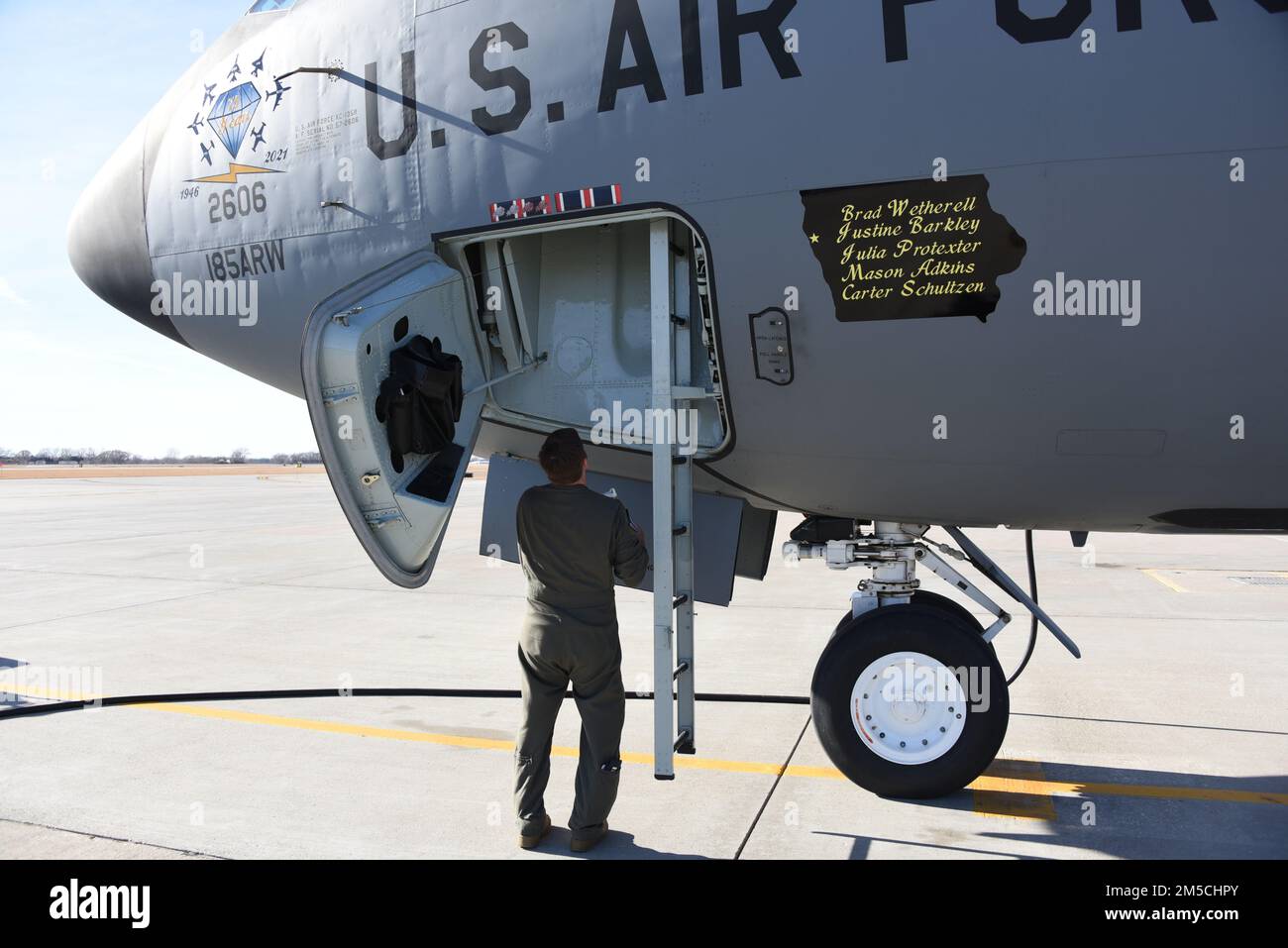 An Iowa Air National Guard pilot exits the crew hatch of a U.S. Air Force KC-135 on the ramp in Sioux City, Iowa on March 1, 2022. The side of the aircraft tail number 57-2606 has a silhouette of the state of Iowa with the names of the assigned crew chiefs. The diamond nose art was created in celebration of the Sioux City Air National Guard’s 75th anniversary. U.S. Air National Guard photo Senior Master Sgt. Vincent De Groot 185th ARW Wing PA Stock Photo