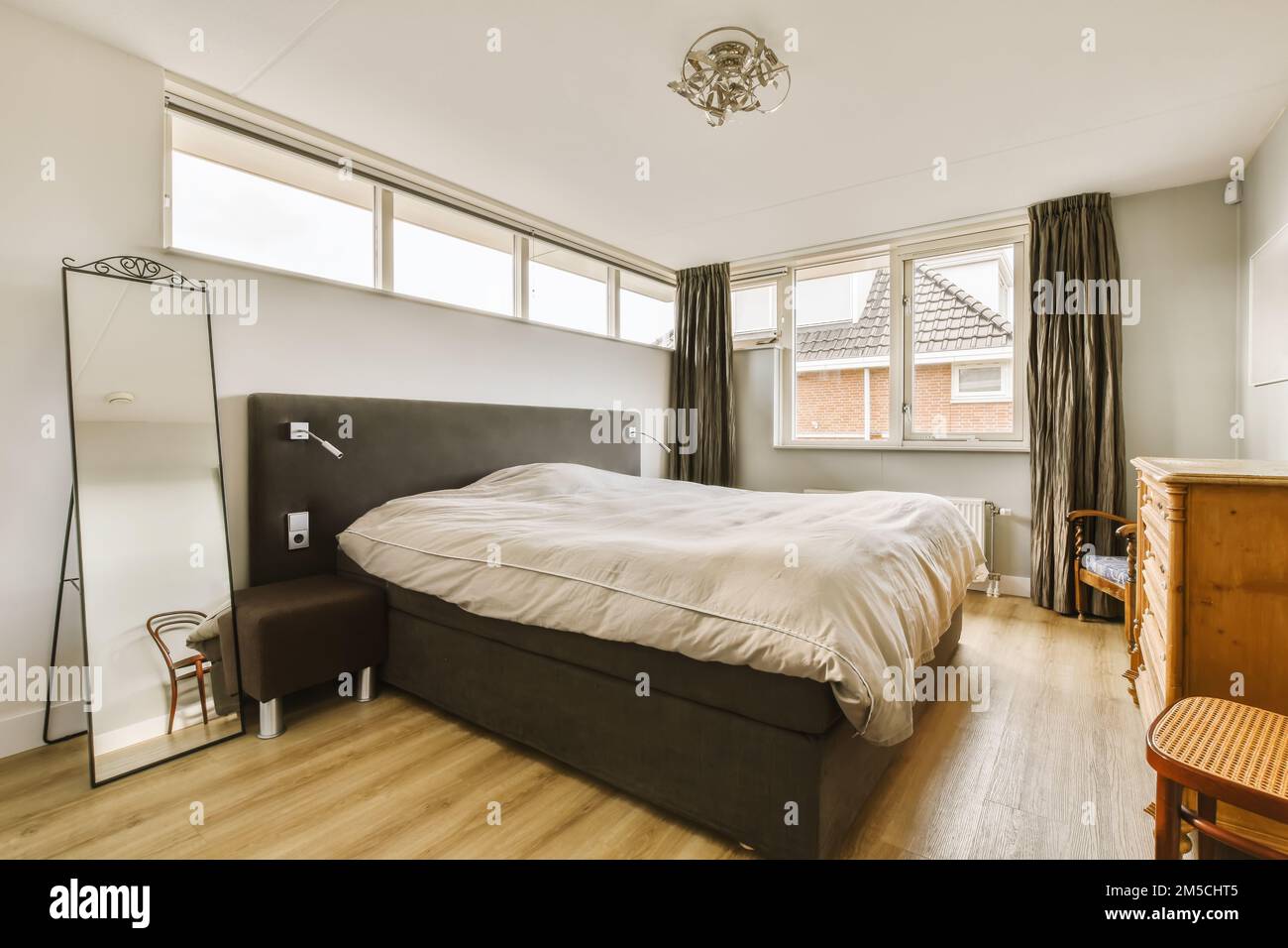 a bedroom with a bed, dresser and window in the corner to the left is ...