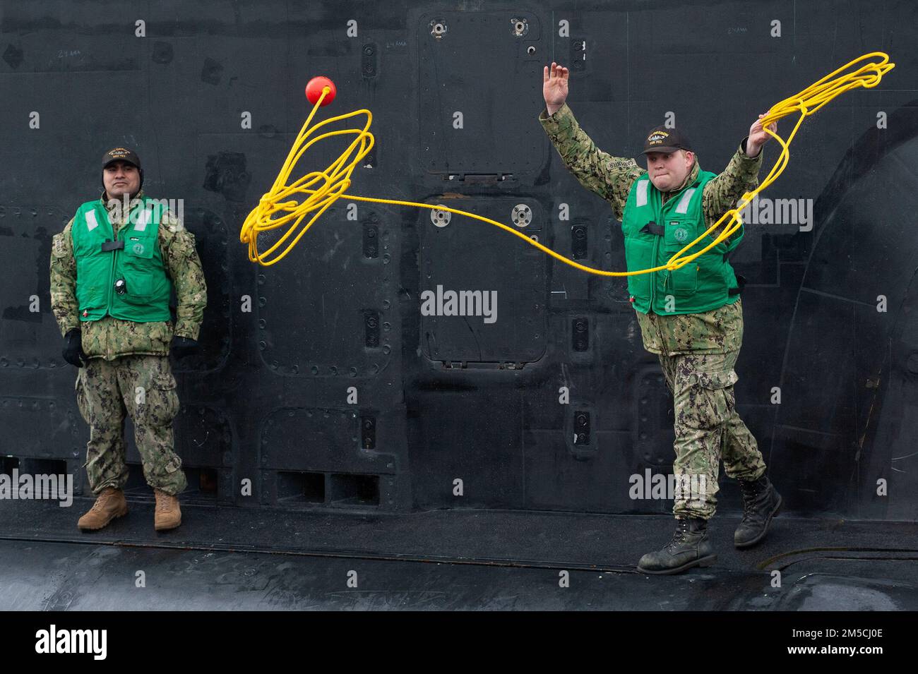 Sonar Technician (Submarines) 3rd Class Dylan Carpenter throws lines while Fire Control Technican 2nd Class Martin Varela looks on moments after the future USS Oregon (SSN 793) arrived at Submarine Base New London in Groton, Conn., for the first time on Tuesday, March 1, 2022.  When commissioned in the coming months, Oregon will be the third U.S. Navy vessel to be named for the 33rd state and will be the 20th Virginia class submarine. Stock Photo