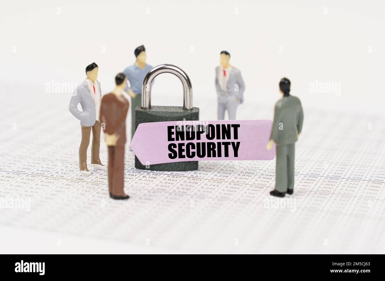 The concept of security in business. There are figures of people on business reports, a padlock with a sticker on which it is written - Endpoint secur Stock Photo