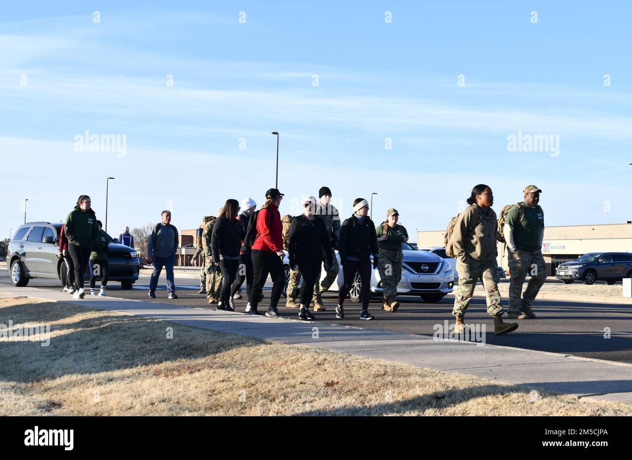 Airmen and their families from the 97th Air Mobility Wing participate in a ruck march in honor of Women’s History Month at Altus Air Force Base, Oklahoma, March 1, 2022. The route began at the Wings of Freedom Park and went down the perimeter road. Stock Photo