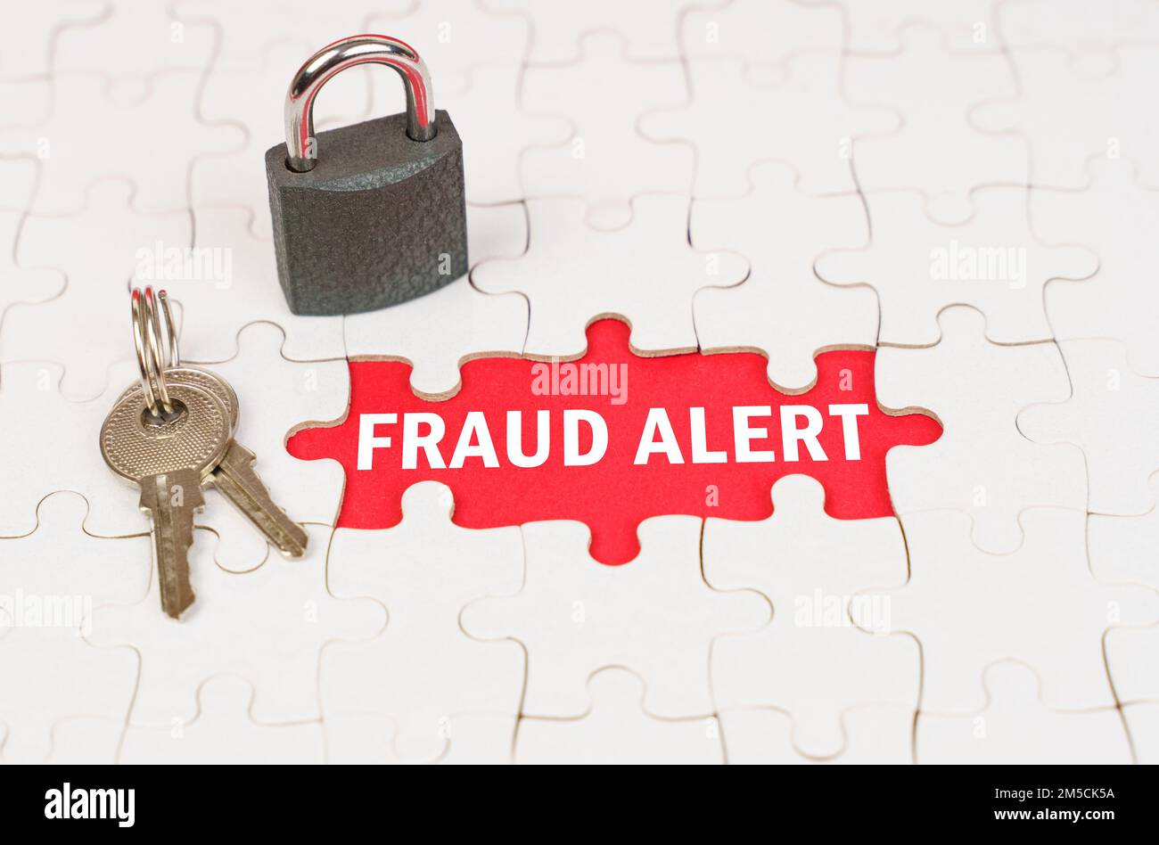 Business and security concept. On puzzles there is a lock and keys, on a red surface there is an inscription - Fraud alert Stock Photo