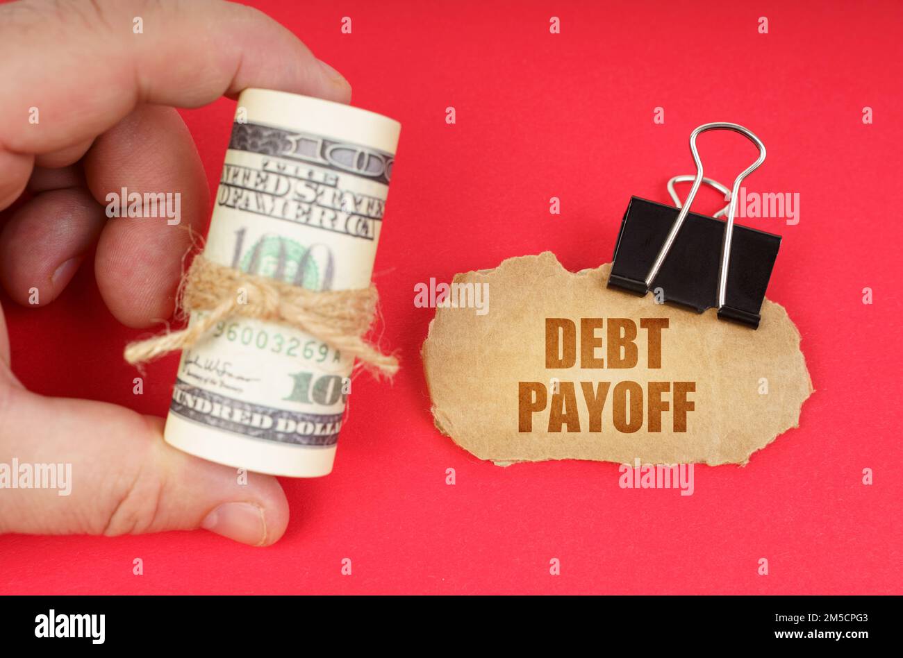 Payoffs Sign Business concept. The man has dollars in his hands, on a red surface ...