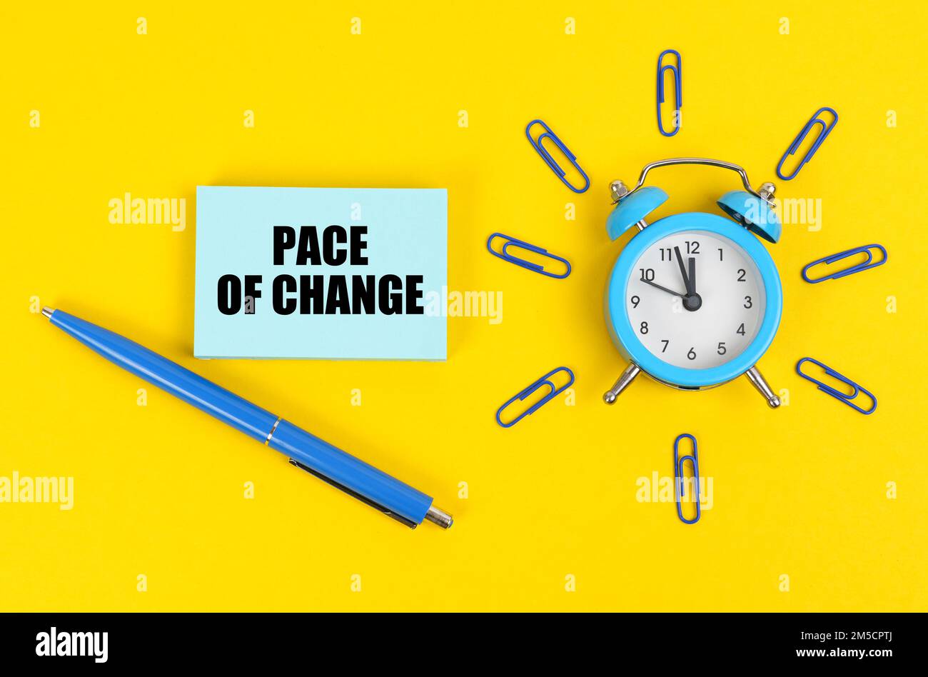 Business concept. On the yellow surface there is an alarm clock, a pen and stickers with the inscription - Pace of Change Stock Photo