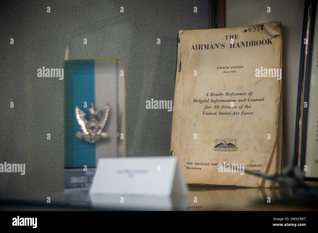 A copy of the Airman’s Handbook from 1954 is showcased in a display cabinet in the Airman Leadership School auditorium March 2, 2022, at MacDill Air Force Base, Florida. ALS is the first level of Professional Military Education that enlisted Airmen experience, teaching them entry-level leadership skills to prepare Airmen for positions of greater responsibility. Stock Photo