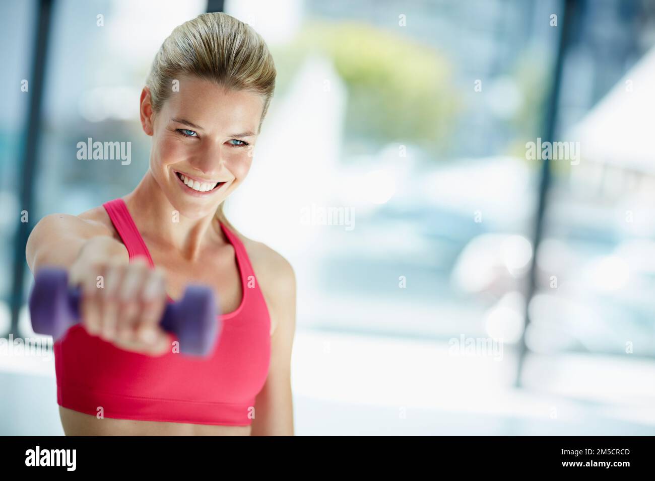 Exercising with a smile. an attractive young woman working out with dumbbells. Stock Photo
