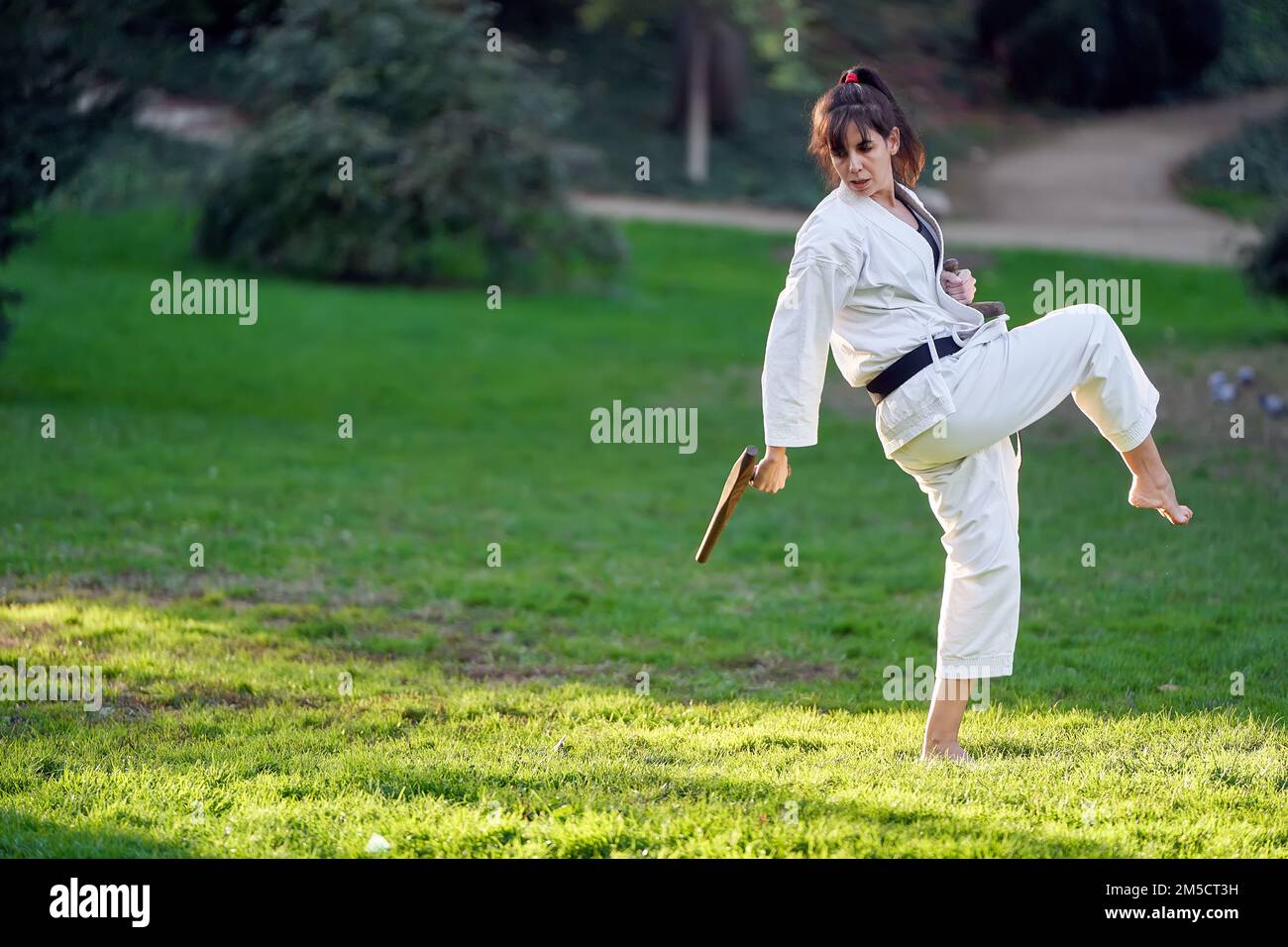 Karate woman in kimono and black belt training outdoors. Sports and martial arts concept. Stock Photo