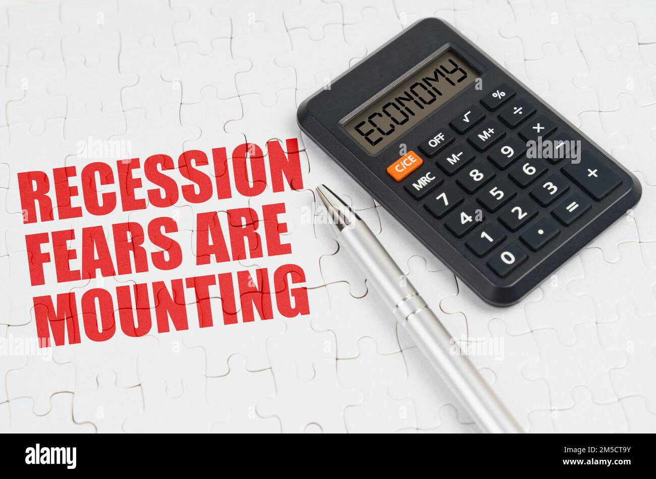 Business concept. On the puzzles lies a calculator and a pen, next to the inscription - Recession fears are mounting Stock Photo