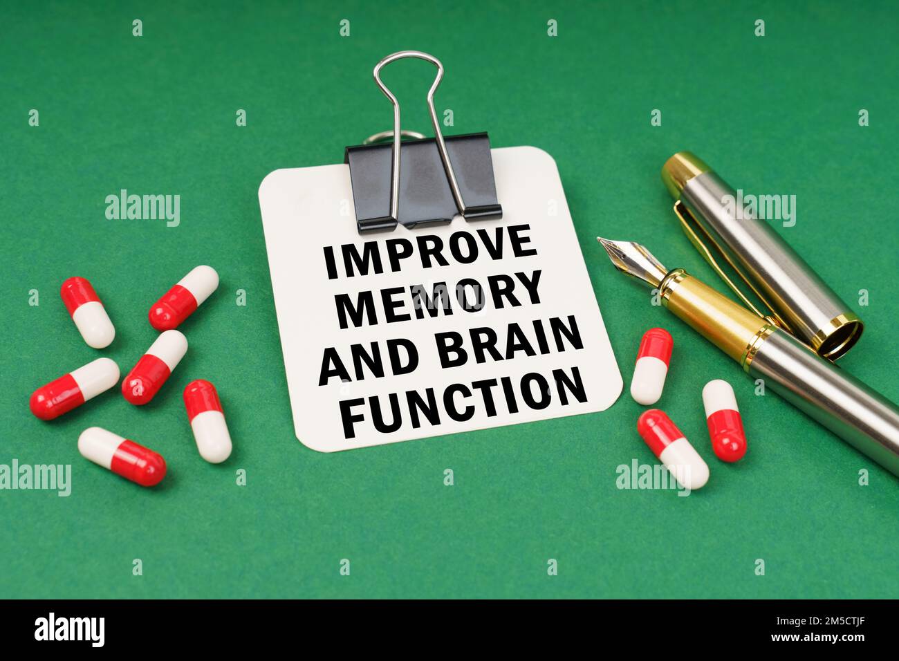 Medical concept. On the green surface of the tablet, a pen and a notepad with the inscription - Improve memory and brain function Stock Photo