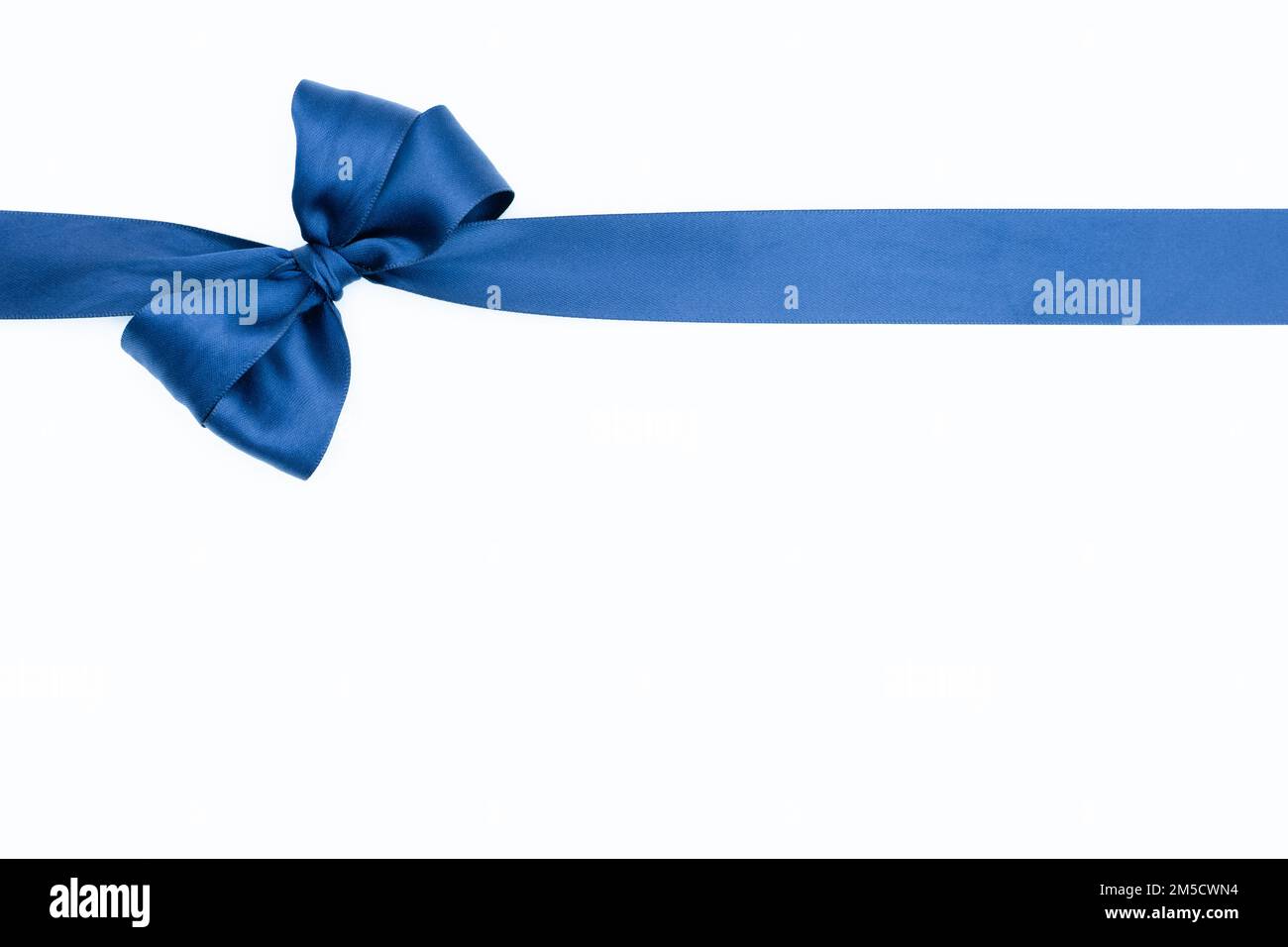 Satin ribbon bow for gift box in blue color, isolated on white