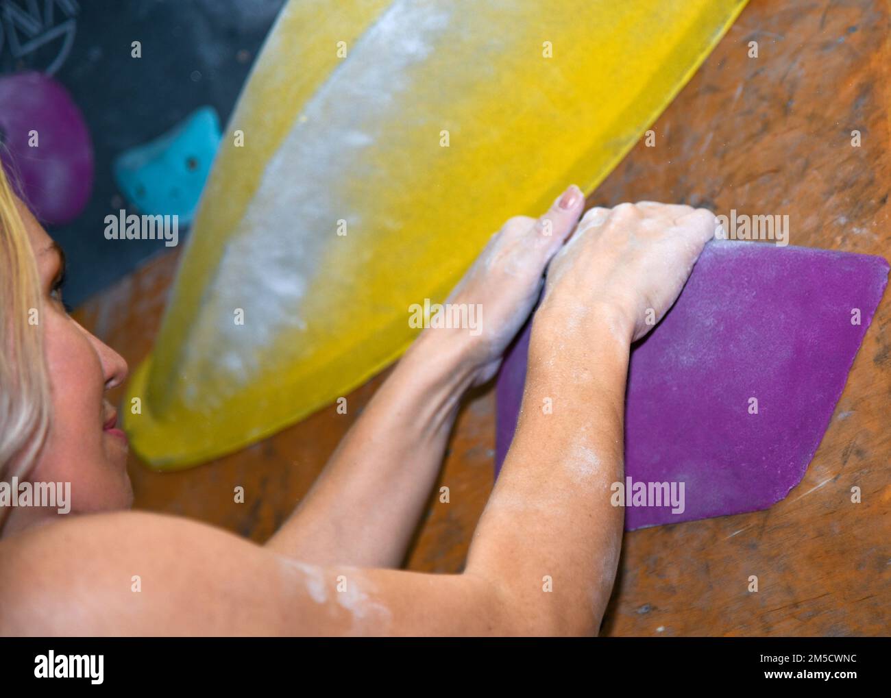Bouldering, beautiful girl look on the climbing wall. Assessment