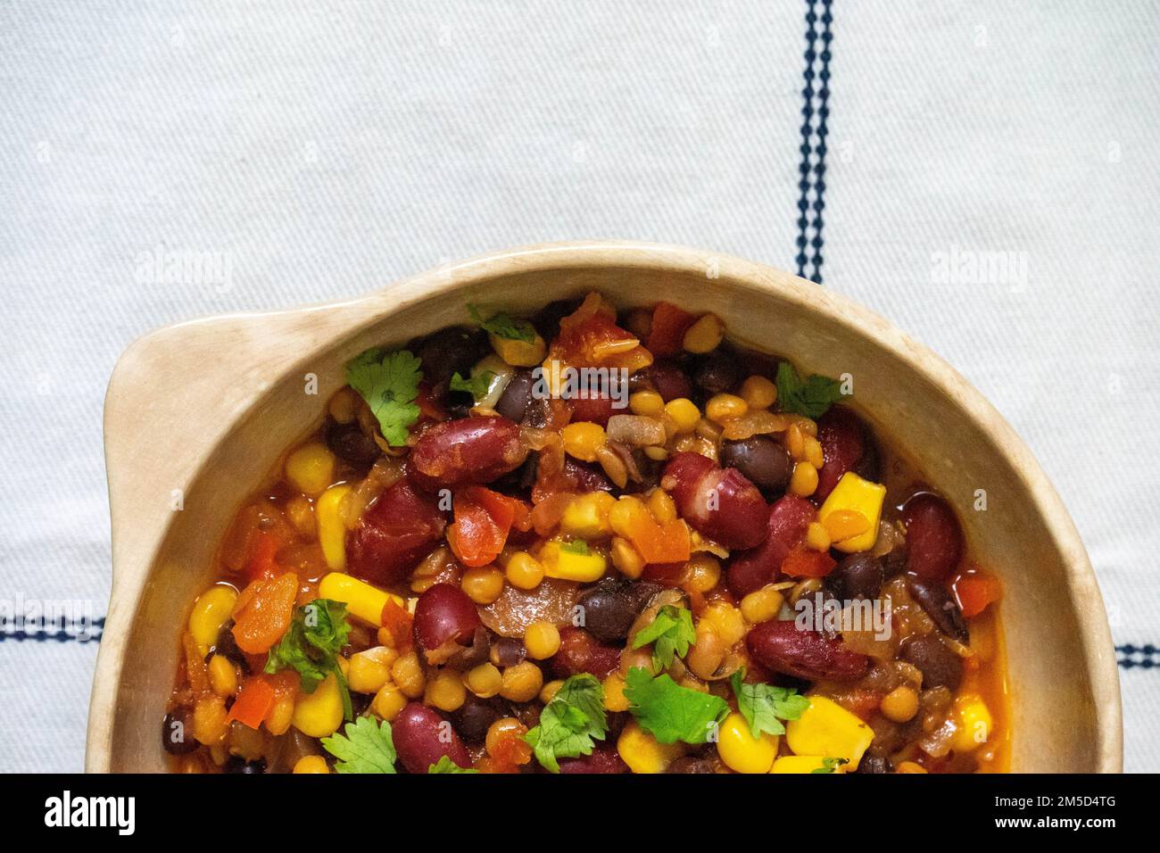Three bean vegetarian chili. Made with black, white and red beans and corn. Accompanied with white rice. Stock Photo