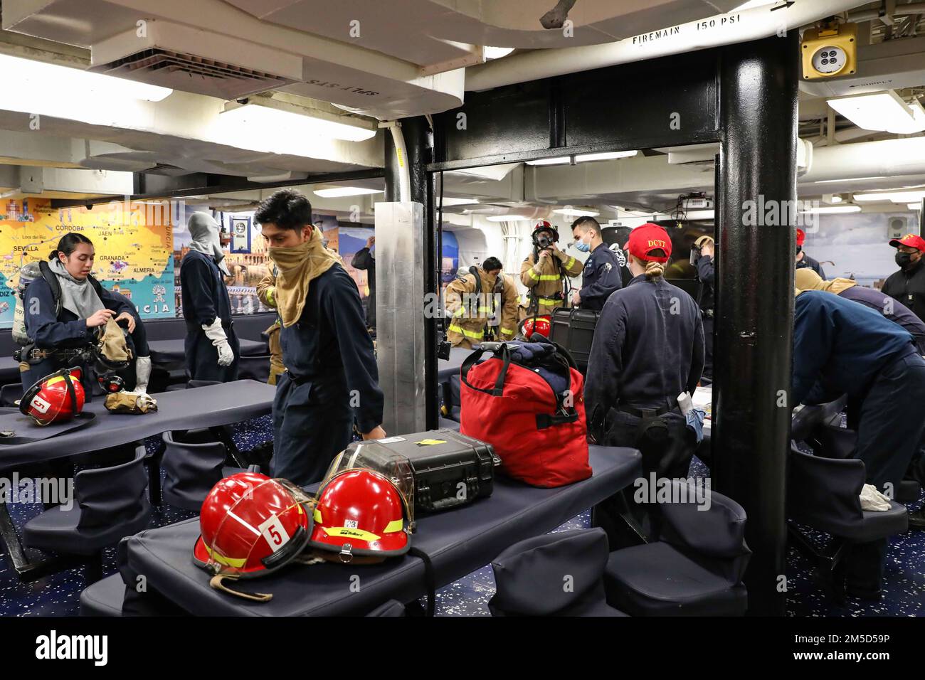 220303-N-UN585-1024 MEDITERRANEAN SEA (March 3, 2022) Sailors assigned to the Arleigh Burke-class guided-missile destroyer USS Ross (DDG 71) don firefighting equipment during a damage control drill, March 3, 2022. Ross, forward-deployed to Rota, Spain, is on its 12th patrol in the U.S. Sixth Fleet area of operations in support of regional allies and partners and U.S. national security interests in Europe and Africa. Stock Photo