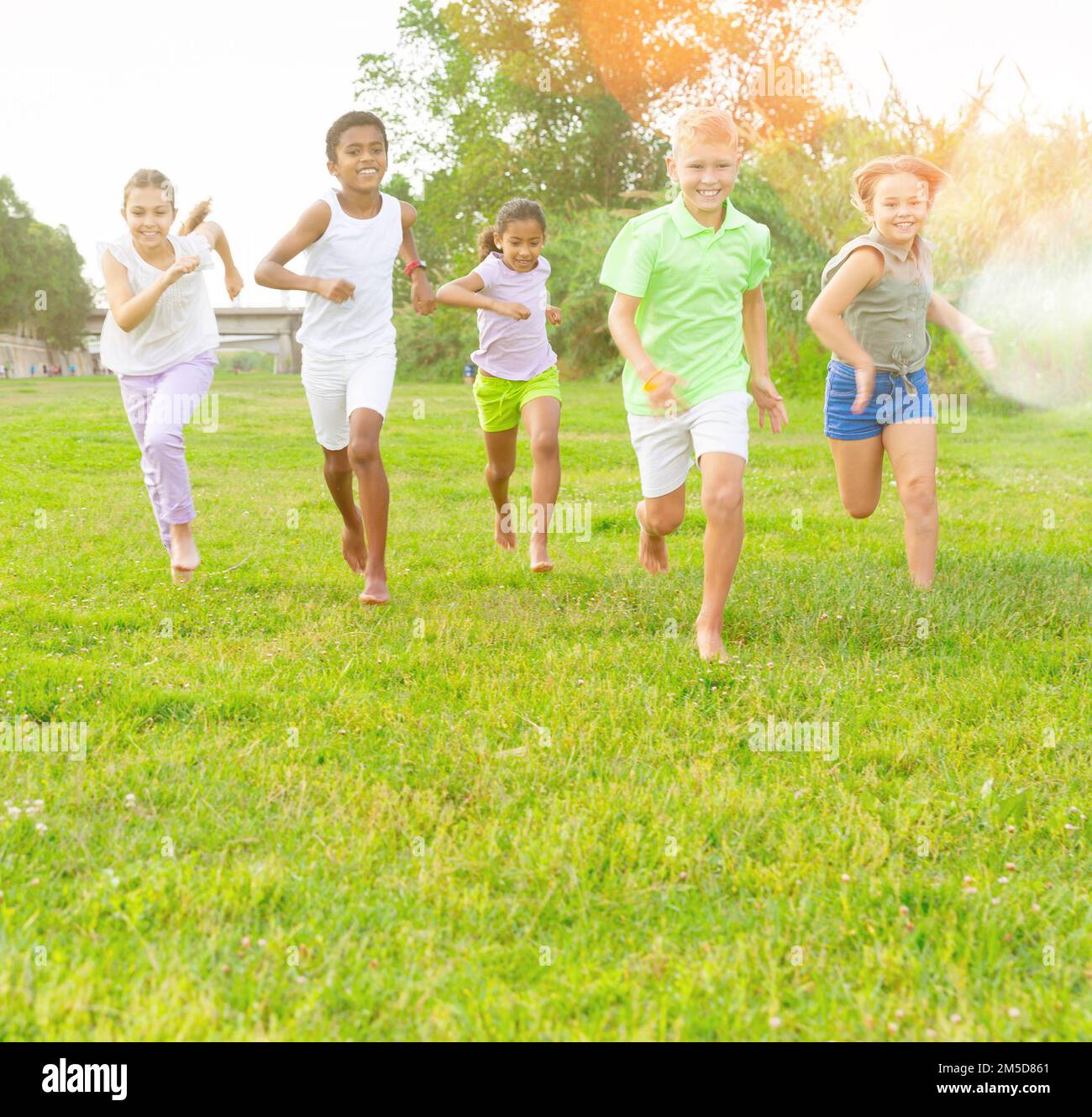 Five smiling kids running and laughing in park Stock Photo - Alamy