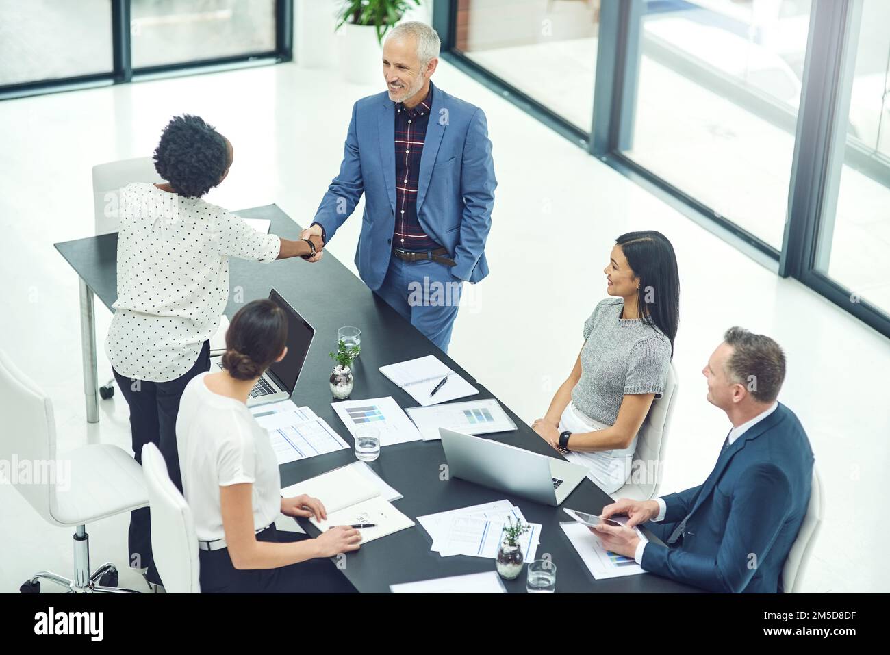 Exceptional work never goes unnoticed. businesspeople shaking hands during an office meeting. Stock Photo