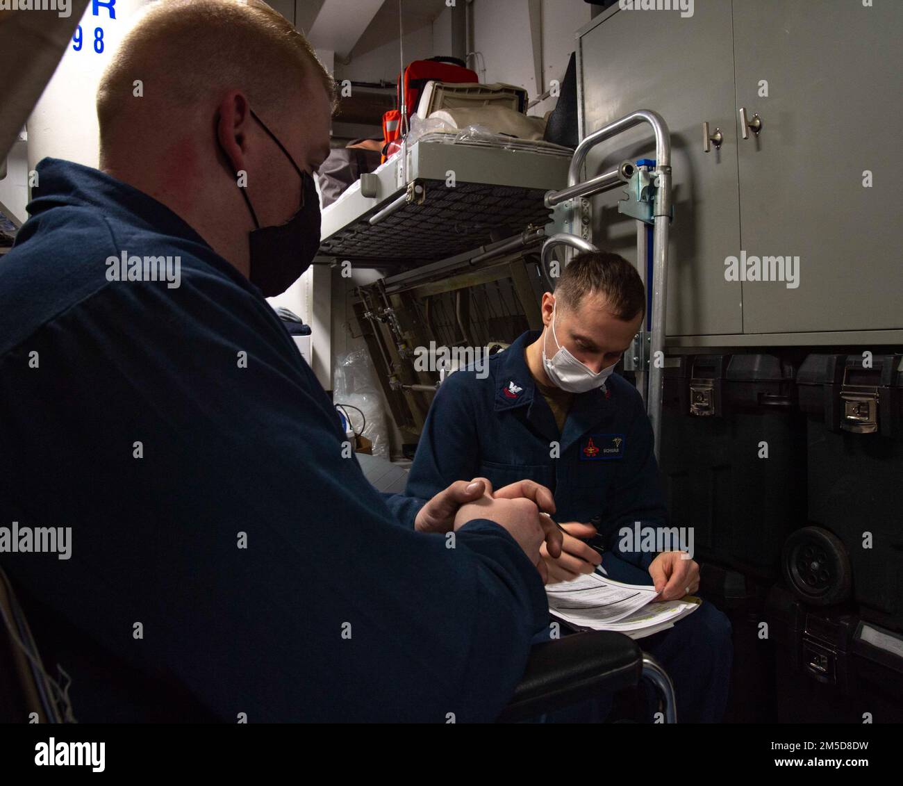 220303-N-WD859-1028 ATLANTIC OCEAN (March 3, 2022) Hospital Corpsman 2nd Class Joshua Schwab, right, conducts a physical health assessment with Machinist’s Mate 1st Class Jeremy Fredell aboard the aircraft carrier USS George H.W. Bush. George H.W. Bush provides the national command authority flexible, tailorable war fighting capability through the carrier strike group that maintains maritime stability and security in order to ensure access, deter aggression and defend U.S., allied and partner interests. Stock Photo