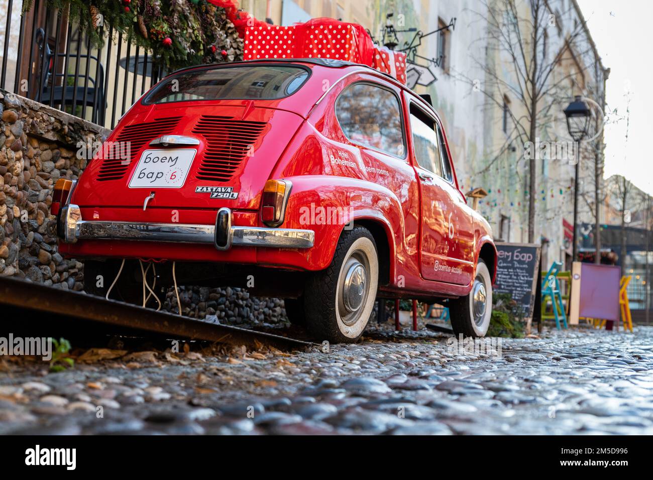 Belgrade, Serbia - December 23, 2022: Oldtimer showcase red car with Christmas presents on the roof in the Skadarlija street in Belgrade, Serbia Stock Photo