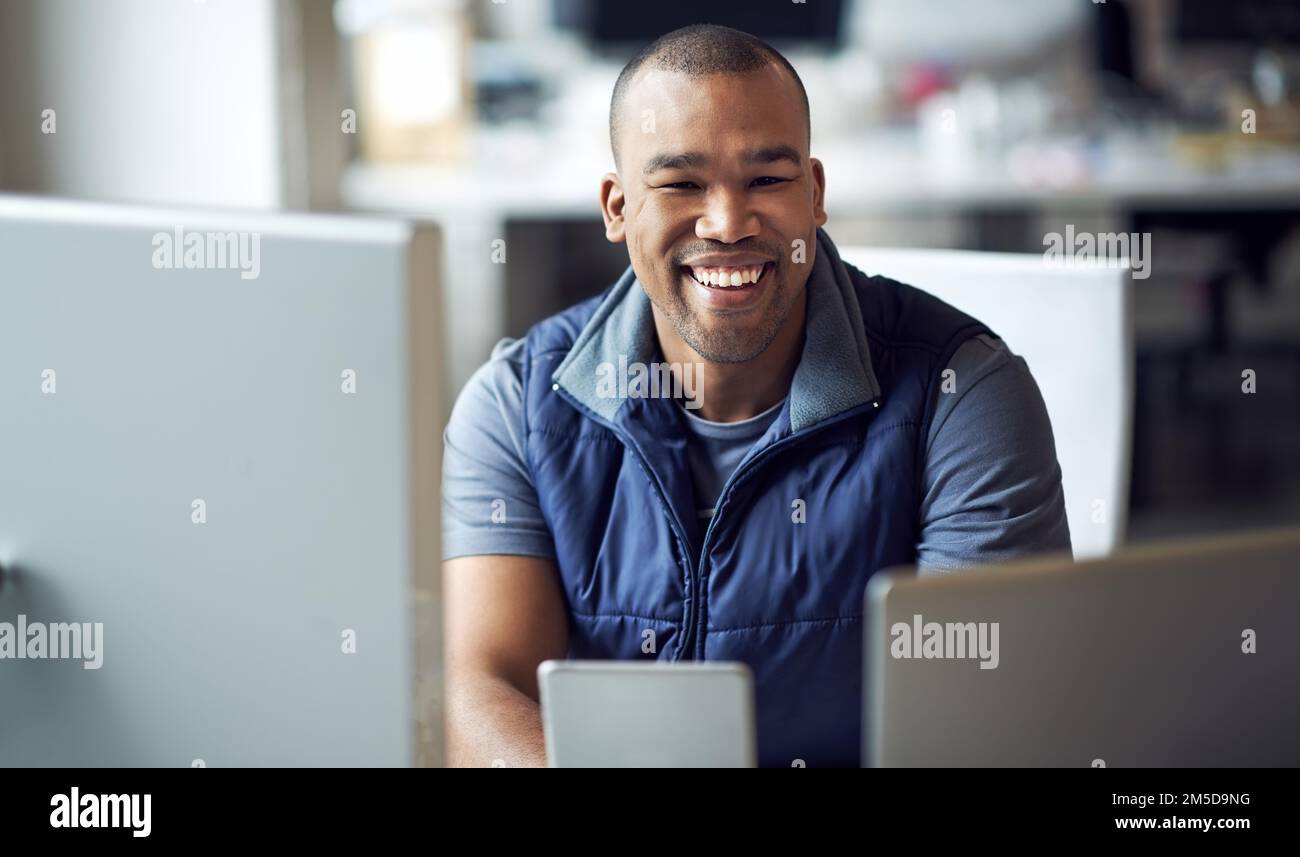 His can-do attitude has made a positive difference. Portrait of a young designer sitting at his desk. Stock Photo