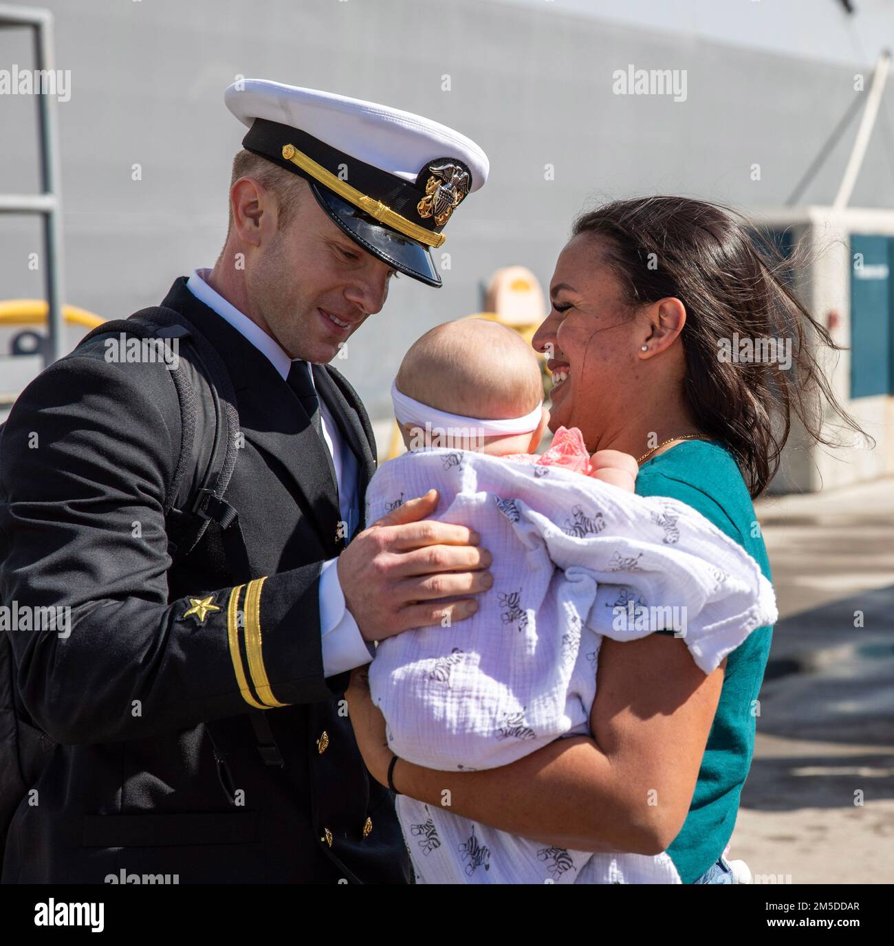 220304-N-LR905-2163  SAN DIEGO (March 4, 2022) – Lt. j.g. Mather, currently assigned to amphibious transport dock ship USS Portland (LPD 27), embraces his child for the first time March 4. Portland, a part of the Essex Amphibious Ready Group, returned to Naval Base San Diego March 4 after a deployment to U.S. 3rd, 5th, and 7th Fleets in support of regional stability and a free and open Indo-Pacific. Stock Photo