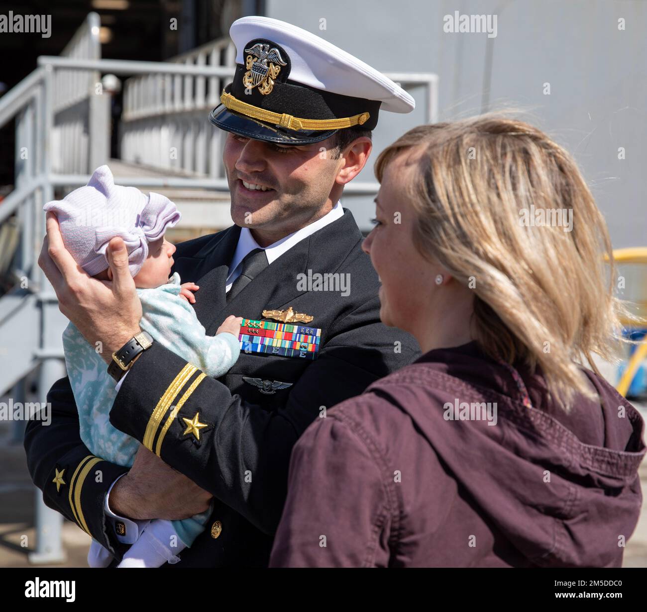 220304-N-LR905-2172  SAN DIEGO (March 4, 2022) – Lt. j.g. Knight, currently assigned to amphibious transport dock ship USS Portland (LPD 27), embraces his child for the first time March 4. Portland, a part of the Essex Amphibious Ready Group, returned to Naval Base San Diego March 4 after a deployment to U.S. 3rd, 5th, and 7th Fleets in support of regional stability and a free and open Indo-Pacific. Stock Photo