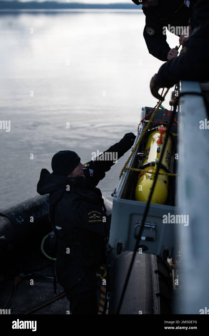 A Royal Canadian Navy Clearance Diver helps lower a REMUS 100 (Remote