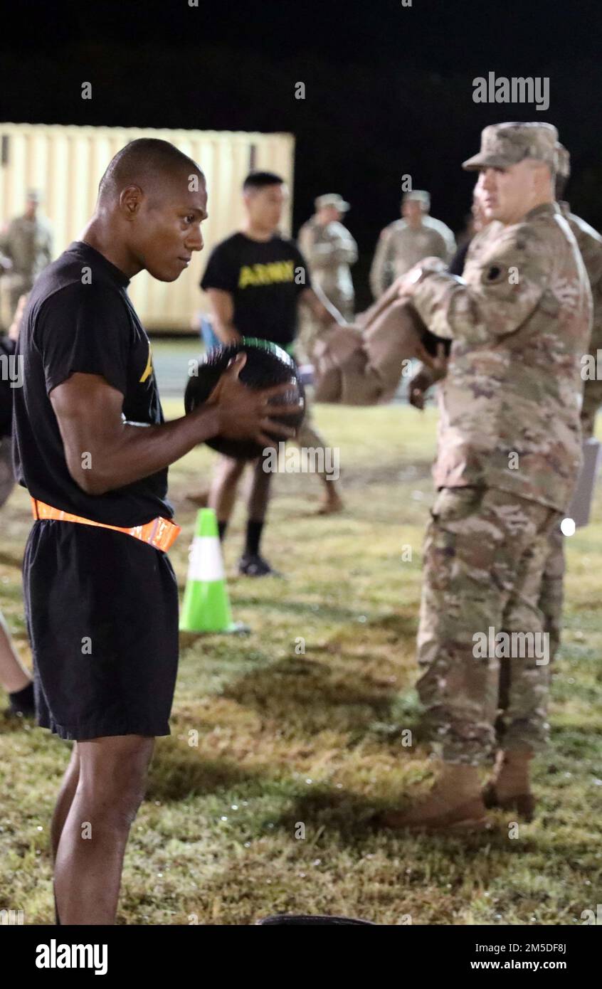 Hawaii Army National Guard (HIARNG) Soldier Spc. Kevin T. Brown, a mass communications specialist assigned to the 117th Mobile Public Affairs Detachment (MPAD), 103rd Troop Command, prepares to throw a 10 pound medicine ball while performing the standing power throw (SPT) event during the annual Best Warrior Competition (BWC) Army Combat Fitness Test (ACFT) at the Regional Training Institute (RTI), Waimanalo, Hawaii, March 4, 2022. The SDC measures upper and lower body explosive power, flexibility and dynamic balance assisting with tasks like a buddy drag, throwing a hand grenade and employing Stock Photo