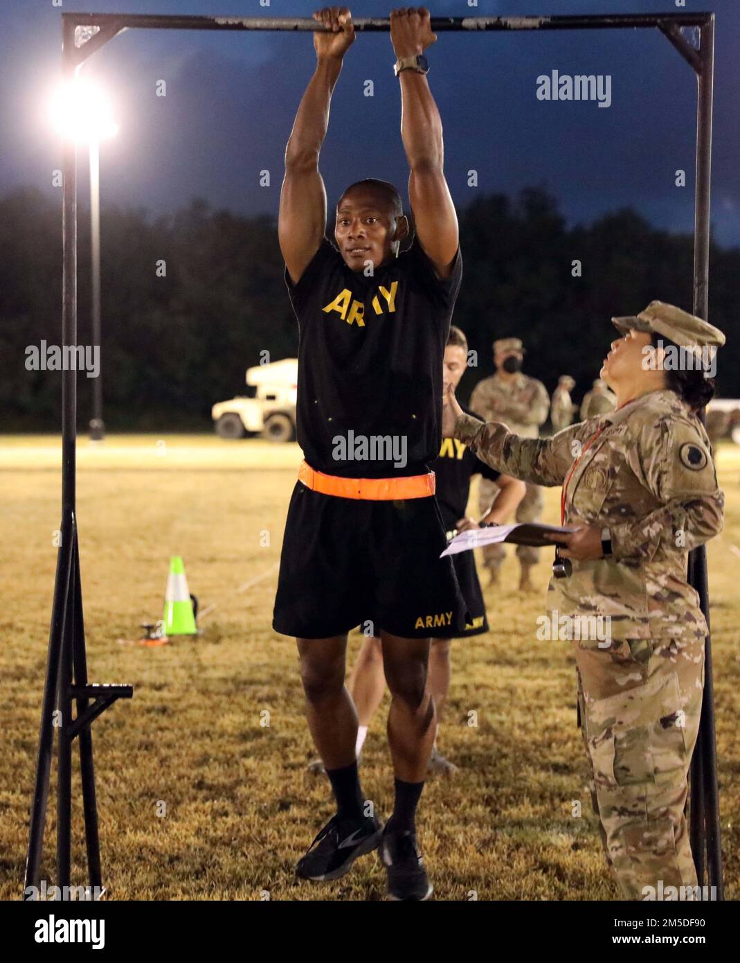 Hawaii Army National Guard (HIARNG) Soldier Spc. Kevin T. Brown, a mass communications specialist assigned to the 117th Mobile Public Affairs Detachment (MPAD), 103rd Troop Command, performs the leg tuck (LTK) event during the annual Best Warrior Competition (BWC) Army Combat Fitness Test (ACFT) event at the Regional Training Institute (RTI), Waimanalo, Hawaii, March 4, 2022. The LTK measures upper and lower body explosive power, flexibility and dynamic balance assisting with tasks like a buddy drag, throwing a hand grenade and employing progressive levels of force in man-to-man contact. Stock Photo