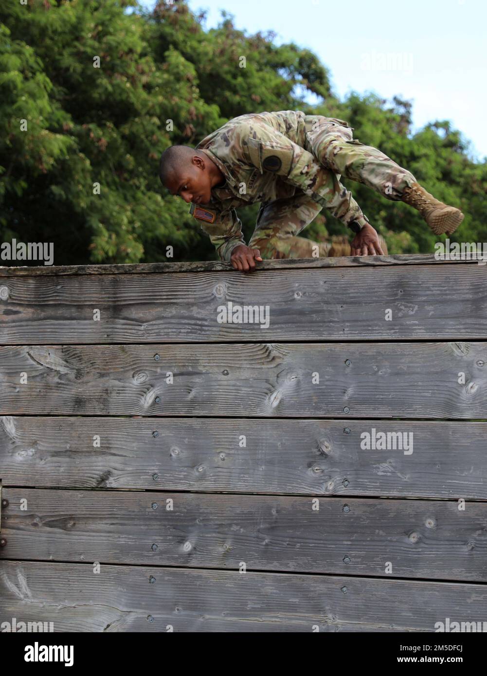 Hawaii Army National Guard (HIARNG) Soldier Spc. Kevin T. Brown, a mass communications specialist assigned to the 117th Mobile Public Affairs Detachment (MPAD), 103rd Troop Command, jumps over the jump and land obstacle during the annual Best Warrior Competition (BWC) obstacle course event at Waimanalo, Hawaii, March 4, 2022. The BWC is an annual three-day event that Soldiers and Non-Commissioned Officers (NCOs) of the HIARNG and Hawaii Army Reserve compete in to earn the title of 'Best Warrior'. The BWC tests Soldiers' individual ability to adapt and overcome challenging scenarios and battle Stock Photo