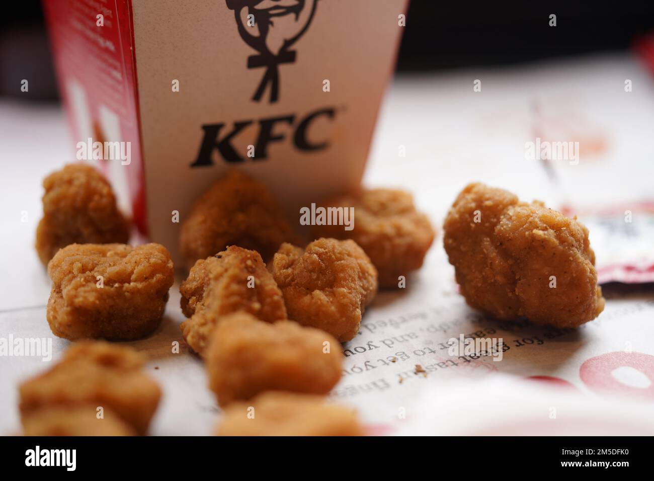 Fried popcorn chicken on the restaurant plate with natural sunlight. KFC restaurant. KFC is a popular fast-food chain known as Kentucky Fried Chicken. Stock Photo