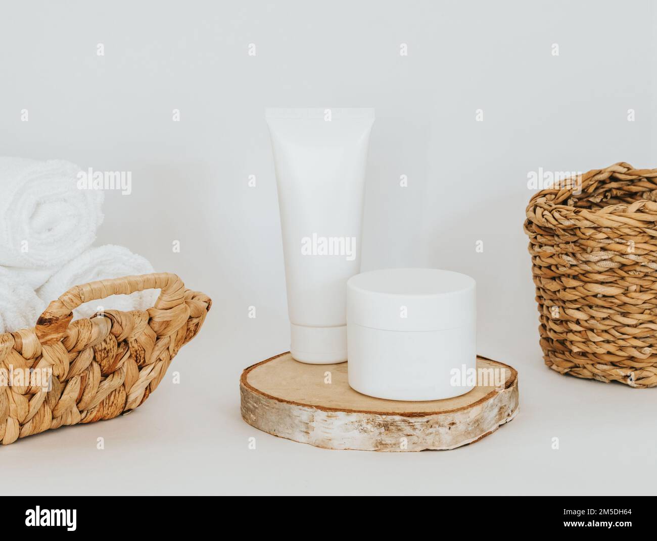 Cosmetic product mockups on round natural podium and bath items on white background. Background for presentation of cosmetic. Front view Stock Photo