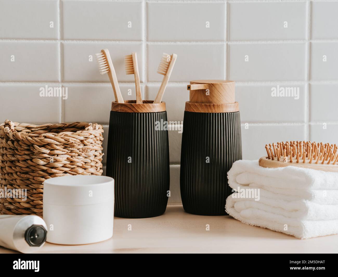 https://c8.alamy.com/comp/2M5DHAT/bath-background-front-view-with-straw-box-container-with-toothbrushes-dispenser-cosmetics-wood-comb-and-white-towels-on-white-background-front-vi-2M5DHAT.jpg