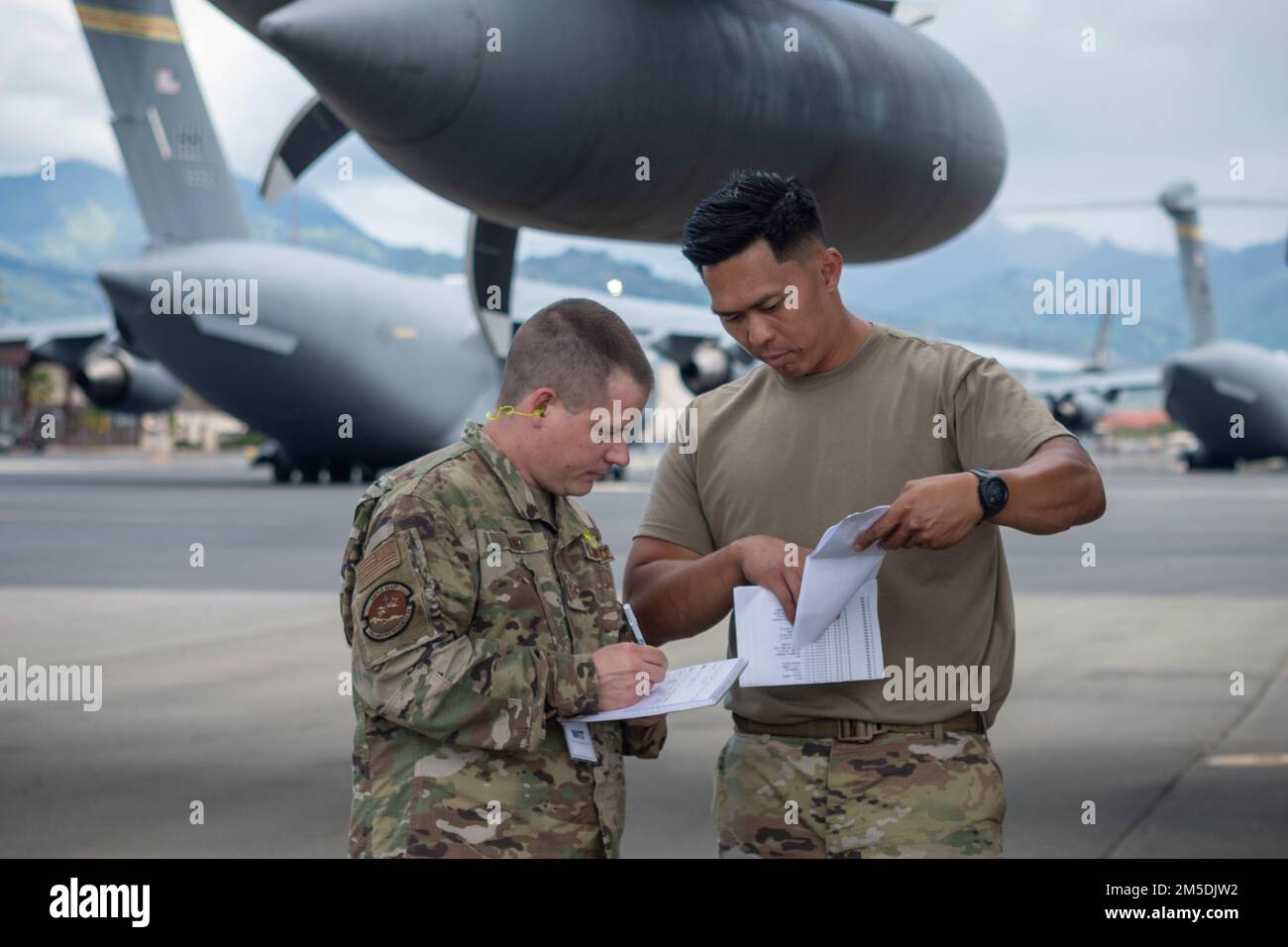 U.S. Air Force Tech. Sgt. Jack Sand, assigned to the 152nd Logistics Readiness Squadron (LRS), left, and Tech. Sgt. Dennis Dedicatoria, assigned to the 154th LRS, review cargo paperwork prior to loading onto a Nevada ANG C-130 Hercules March 5, 2022, at Joint Base Pearl Harbor-Hickam, Hawaii. The Hawaii ANG, Nevada ANG, and their active-duty counterparts from the 15th Wing and Alaska participated in the first-of-its-kind Ho'oikaika Exercise. The exercise served as an opportunity for partnered units to demonstrate and improve their ability to quickly deploy and operate at remote locations. Stock Photo
