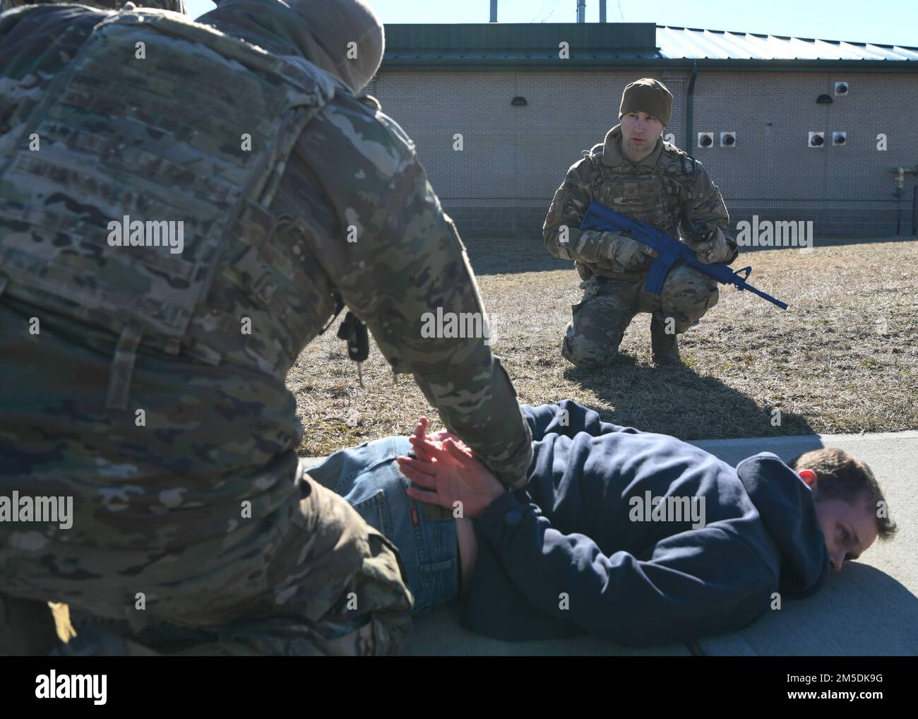 Members of the 106th Security Forces Squadron participate in an installation breach training exercise at NY Air National Guard’s 106th Rescue Wing, Francis S. Gabreski Air National Guard Base, Westhampton Beach, N.Y., March 4, 2022. During the training, the suspect being detained failed to stop at the base entrance and was subsequently arrested by 106th Security Forces. Stock Photo