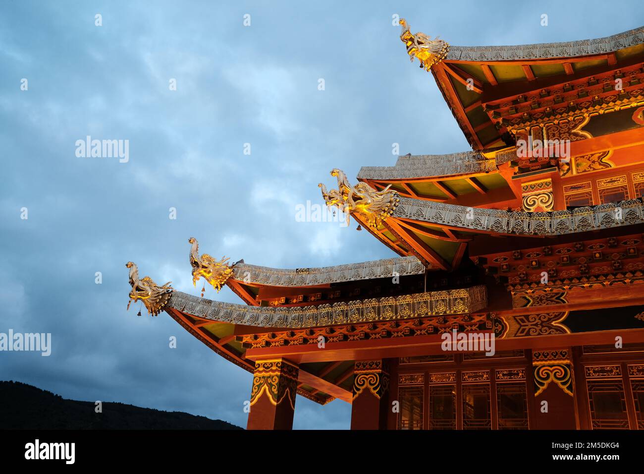 Chinese temple roof in sky background. Traditional chinese roof with orange details and golden ornaments. Orange color roof on the temple in Shangri-l Stock Photo