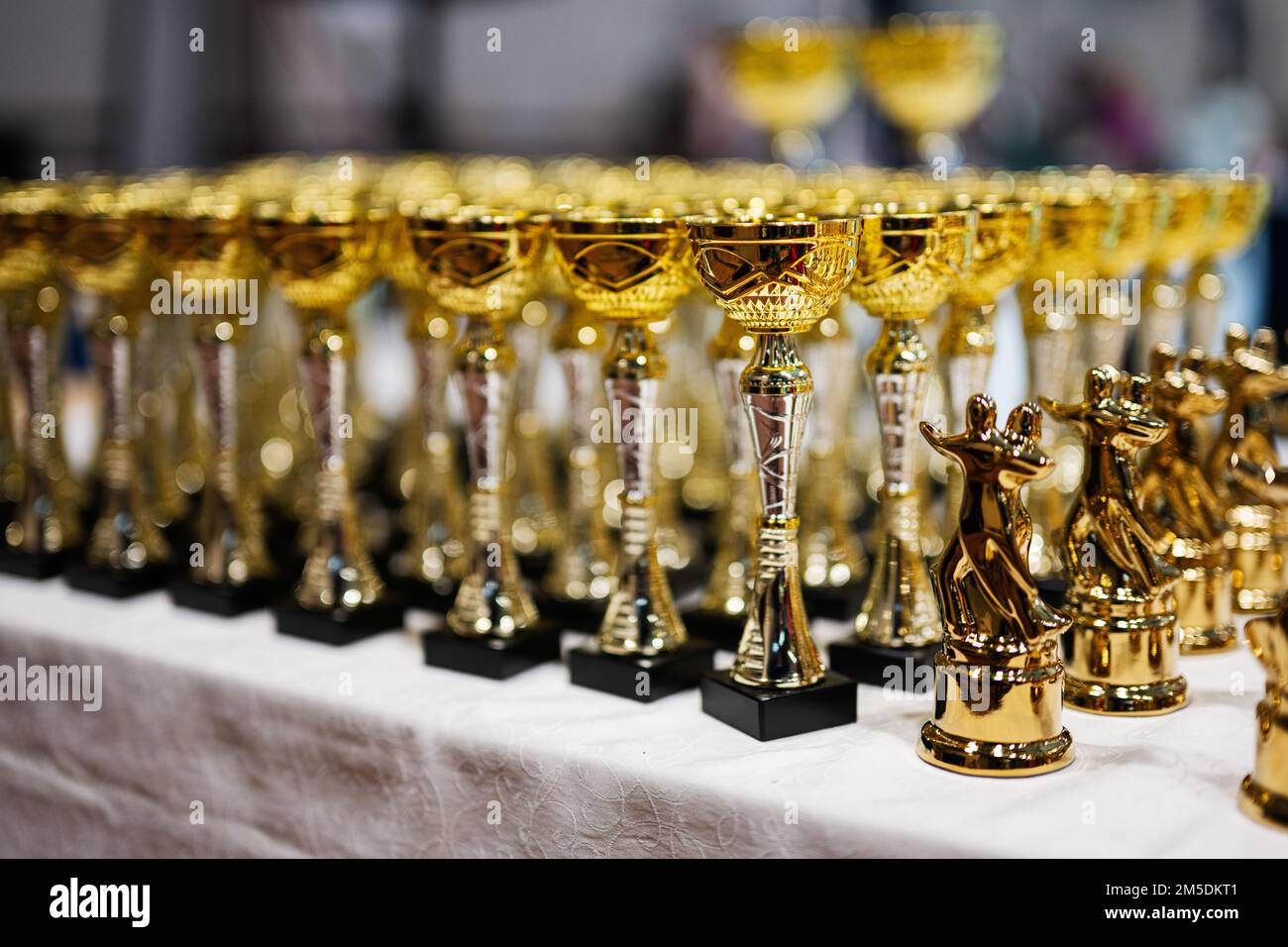 Award and victory concept. Row of golden cups of dance competition