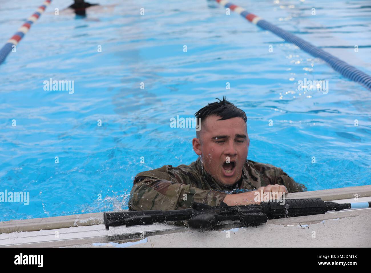 Spc. Roland Link, 415th Chemical Brigade, catches his breath after diving to the bottom of the pool to retrieve his weapon during the swimming event of the CWBC. The FY22 Consortium Best Warrior Competition took place March 2-6 at Camp Bullis on Joint Base San Antonio, Texas. The CBWC is a joint event featuring Soldiers belonging to several Army Reserve Commands from across the nation, to include the 80th Training Command, 807th Medical Command, 76th Operational Response Command, Medical Readiness and Training Command, and the 63rd, 81st, 88th and 99th Readiness Divisions. Stock Photo