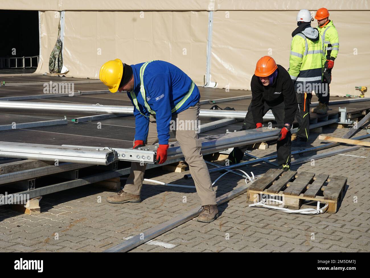 Kellogg, Brown and Root (KBR) contractors assemble a frame for an expeditionary dining facility on Barton Barracks, Ansbach, Germany, March 4, 2022, in preparation to receive forces. The deployment of U.S. forces here is a prudent measure that underpins NATO’s collective war-prevention aims, defensive orientation and commitment to protect all Allies. Stock Photo