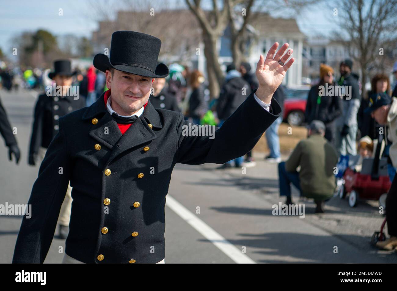 YARMOUTH, Mass. (March 5, 2022) Command Senior Chief Seth Miles, from Payson, Illinois, waves to the crowd during Cape Cod's St. Patrick's Day Parade. USS Constitution, is the world’s oldest commissioned warship afloat, and played a crucial role in the Barbary Wars and the War of 1812, actively defending sea lanes from 1797 to 1855. During normal operations, the active-duty Sailors stationed aboard USS Constitution provide free tours and offer public visitation to more than 600,000 people a year as they support the ship’s mission of promoting the Navy’s history and maritime heritage and raisin Stock Photo