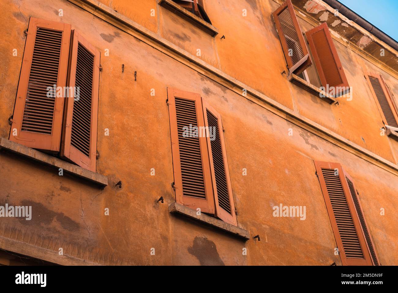 Shutters Italy, view of a colorful building with orange shutters in the scenic old town area of Mantua (Mantova), Lombardy, Italy Stock Photo