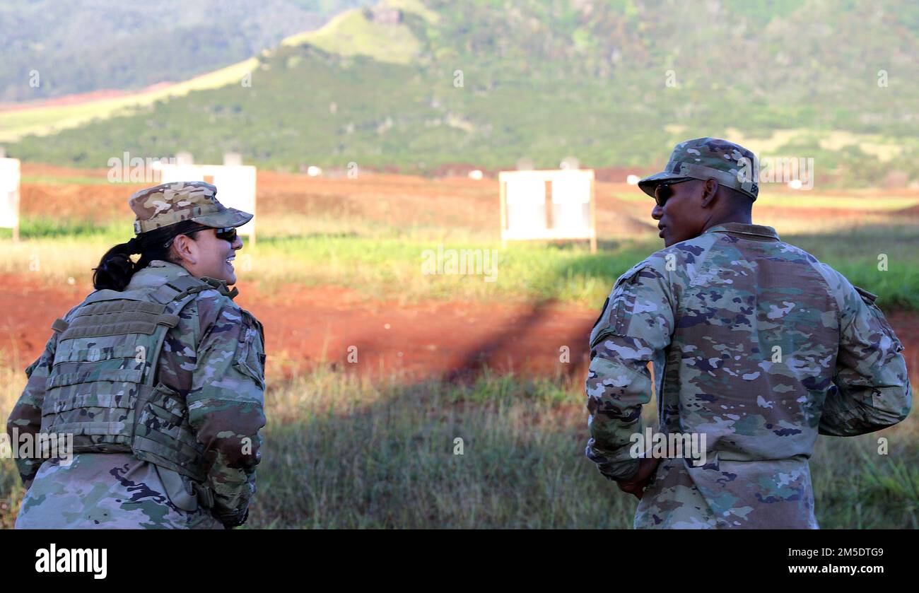U.S. Army Reserve Soldier, Sgt. Gloria Maldonado and Hawaii Army National Guard (HIARNG) Soldier, Spc. Kevin T. Brown, a mass communication specialist with the 117th Mobile Public Affairs Detachment (MPAD), 103rd Troop Command, share a moment of comradery during individual weapons qualification (IWQ), Schofield Barracks, Hawaii, March 5, 2022. The IWQ is one of the events in the Best Warrior Competition (BWC) to test Soldiers’ skills. Stock Photo