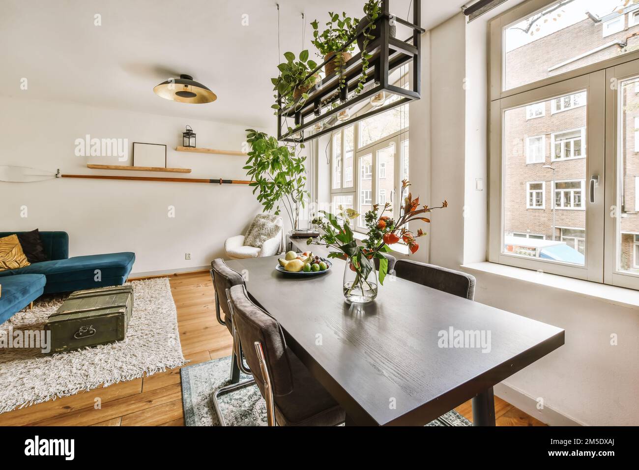 a living room with a table, couch, and plant on the wall in it's
