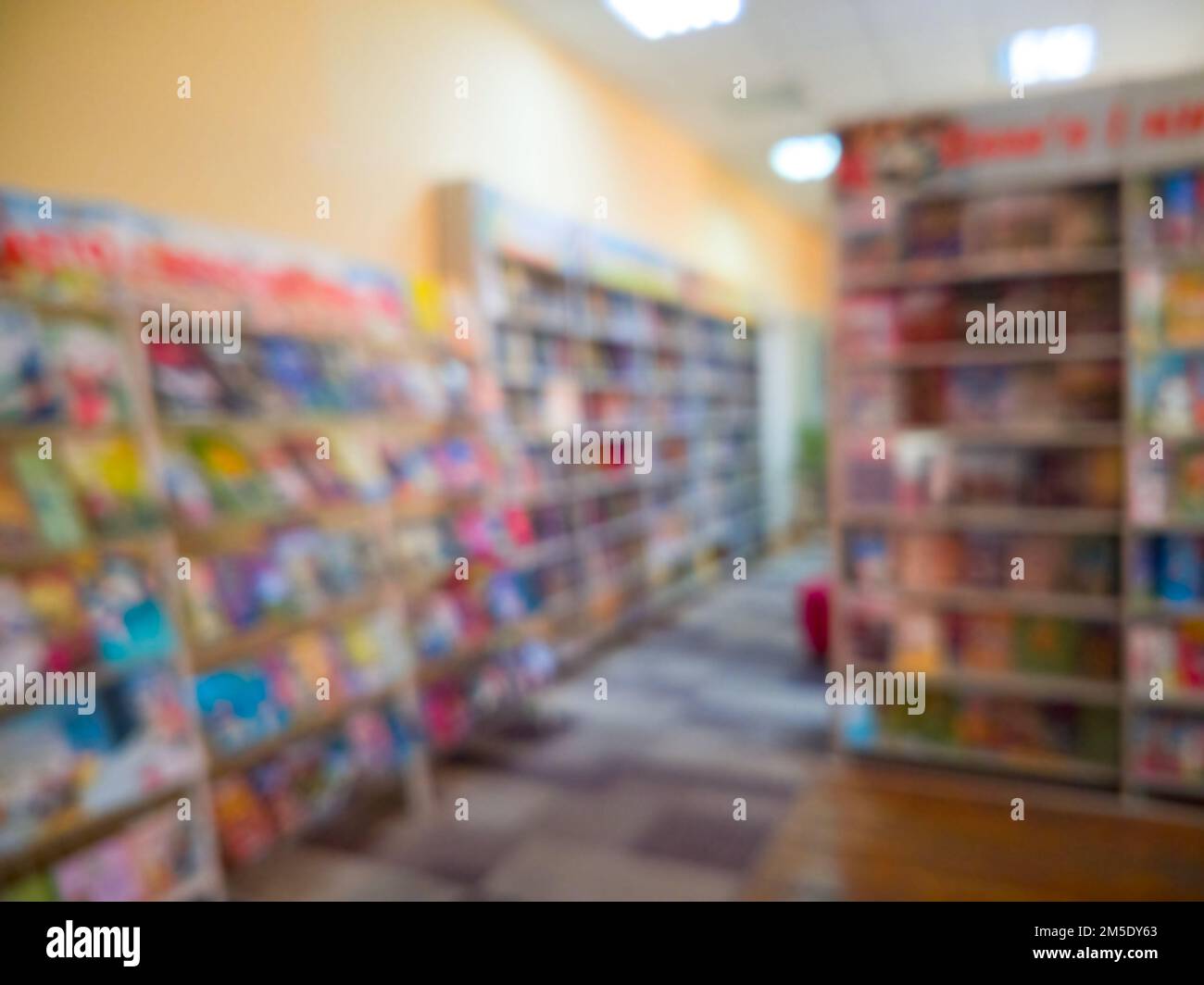 Abstract blur front book store defocused for background usage. Stack of book and bookshelf in book store. Stock Photo